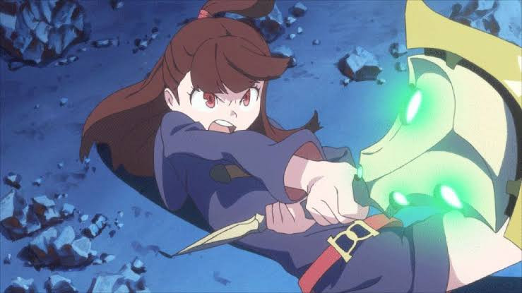 Akko lying dramatically on the ground on her back in an action pose, holding a giant wand, the shiny wand, up, and casting a spell!!!