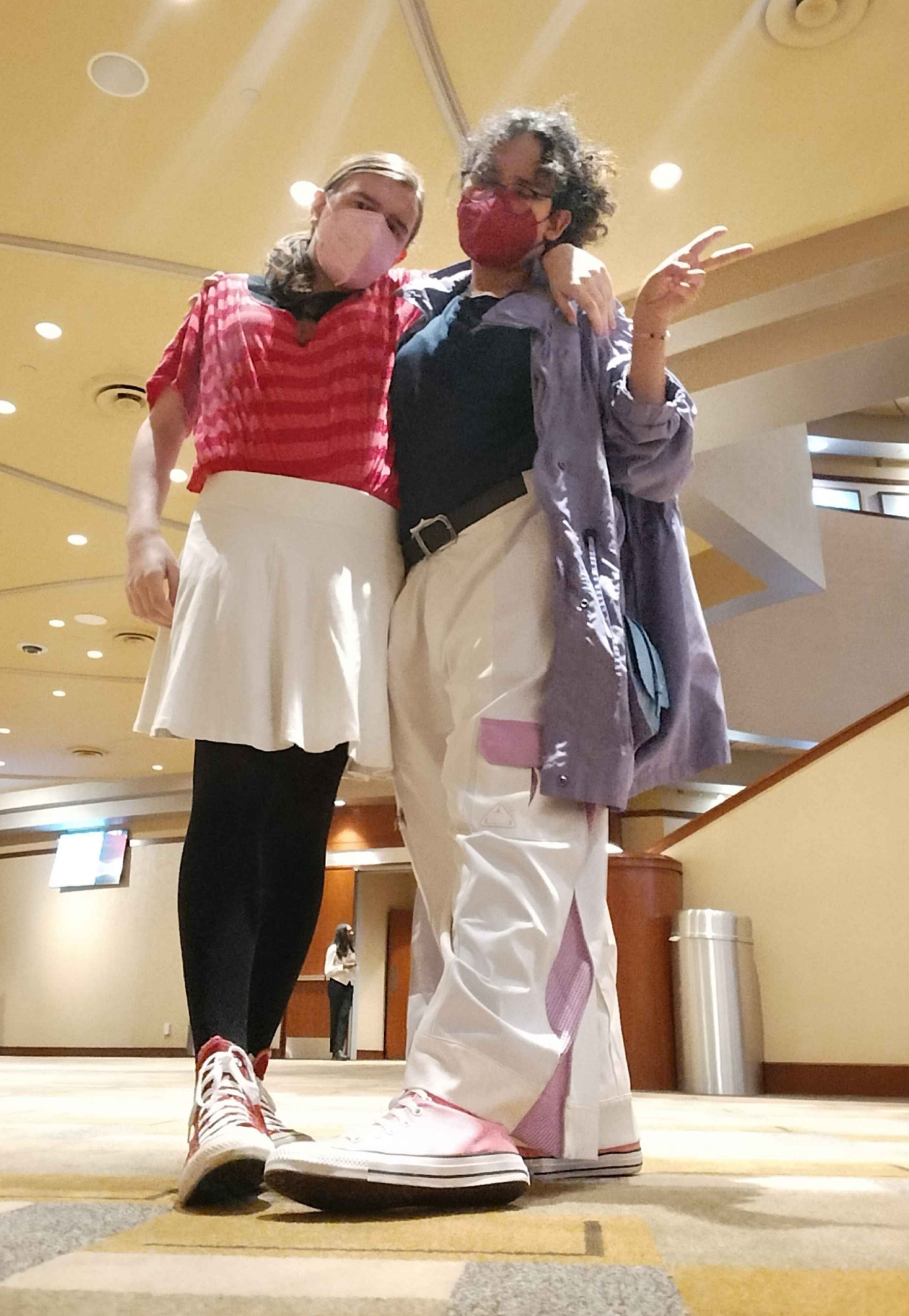 low-angle shot of two women posing, wearing outfits designed after amy rose and blaze the cat