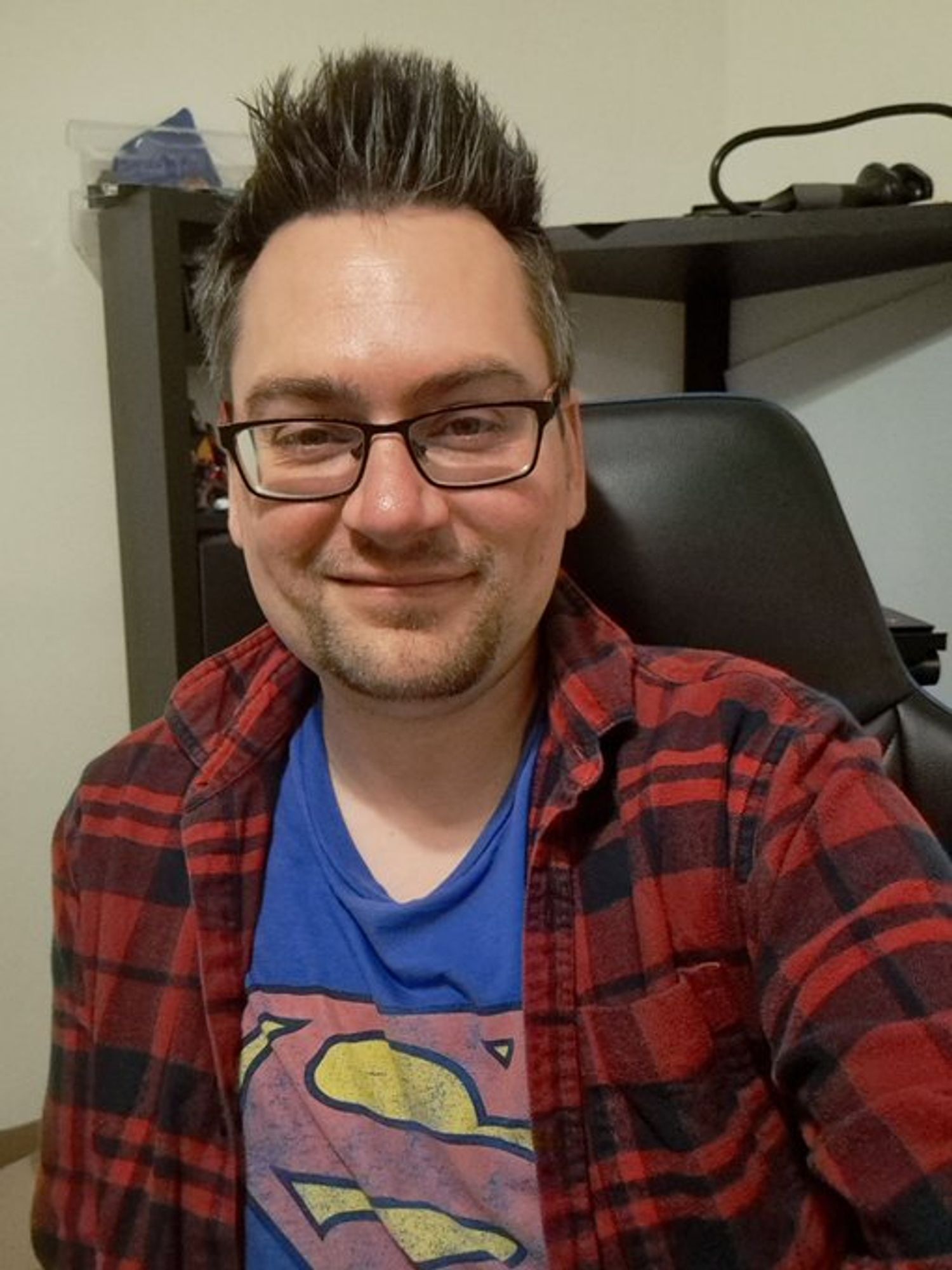 Jeff selfie in a Superman shirt and red flannel, hair looking ON-POINT as ever