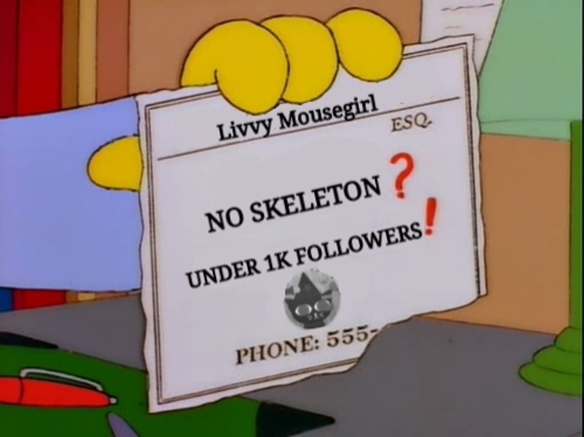 A yellow Simpsons hand holding up a business card. The card reads:

livvy Mousegirl Esquire

No skeleton?

Under 1k followers!

Phone 555-

There is a black and white image of Livy's Halloween pfp above the phone number. The bottom3 corner with the last four digits is torn off.