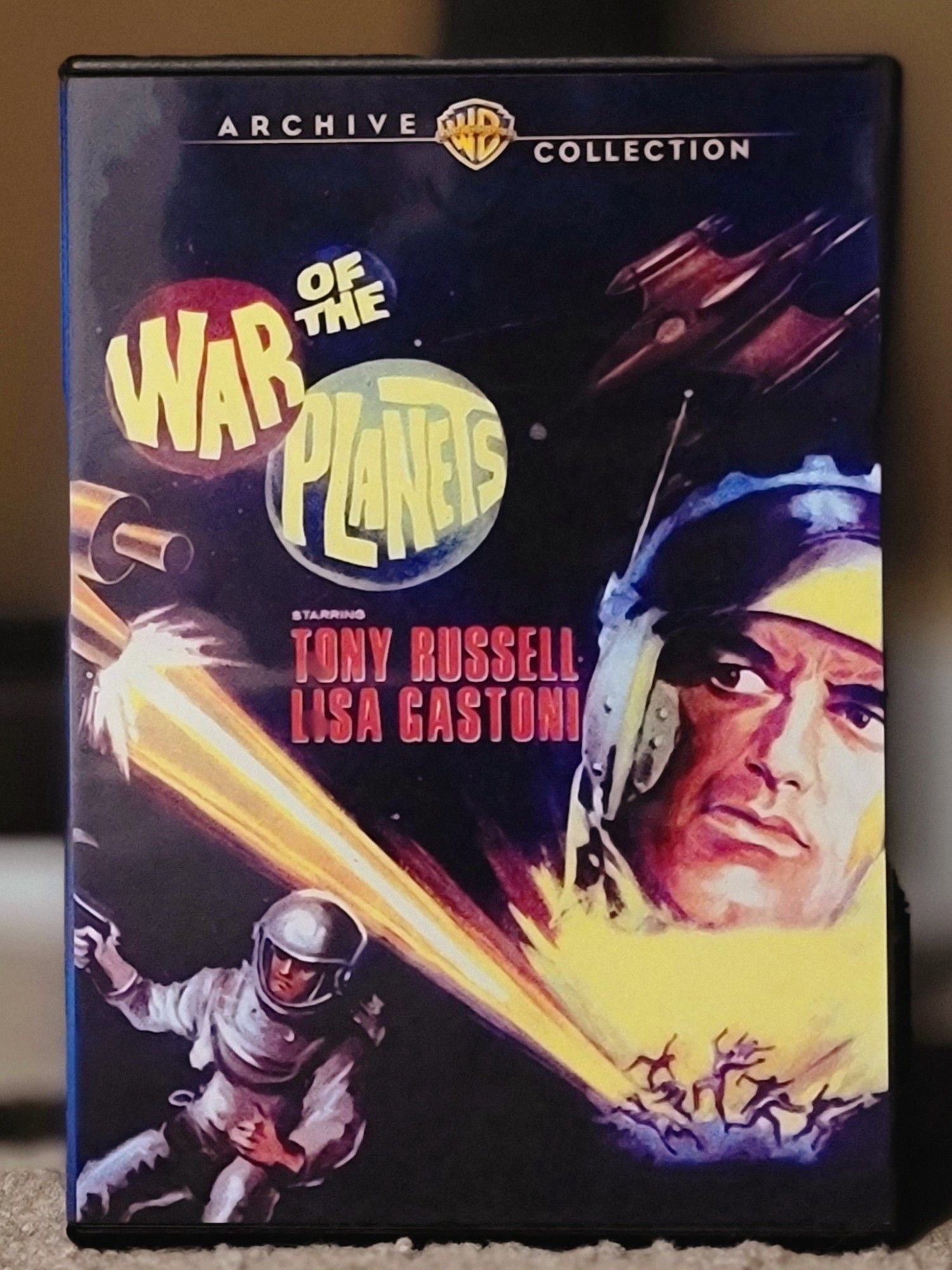 Dvd cover for the film War of the Planets. The art shows some guys in space suits, spaceships, and people getting blasted by a huge laser.