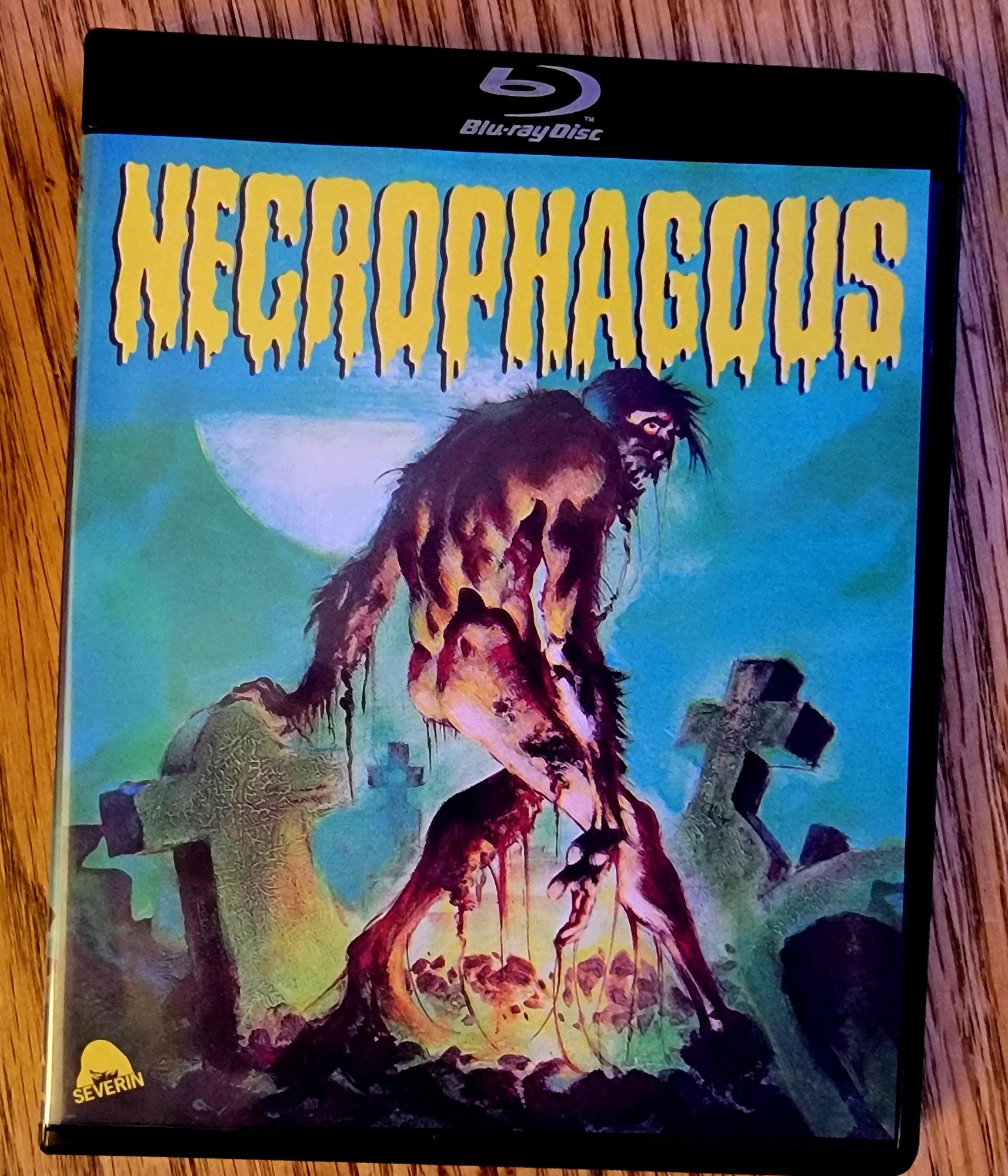 Blu ray cover for the film Necrophagous. It shows a ghoul in a graveyard.