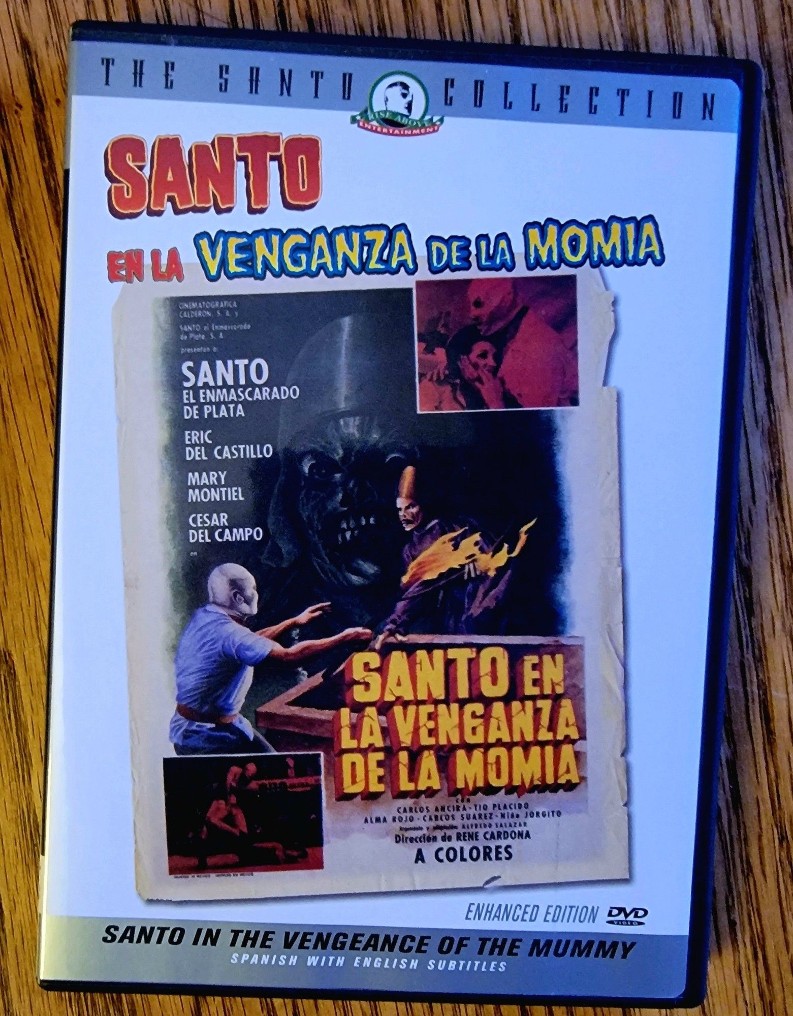 Dvd cover for the film Santo in The Vengeance of the Mummy. The image shows Santo in a tomb with a mummy. There are two smaller images, on of Santo and a woman, the other shows Santo wrestling.