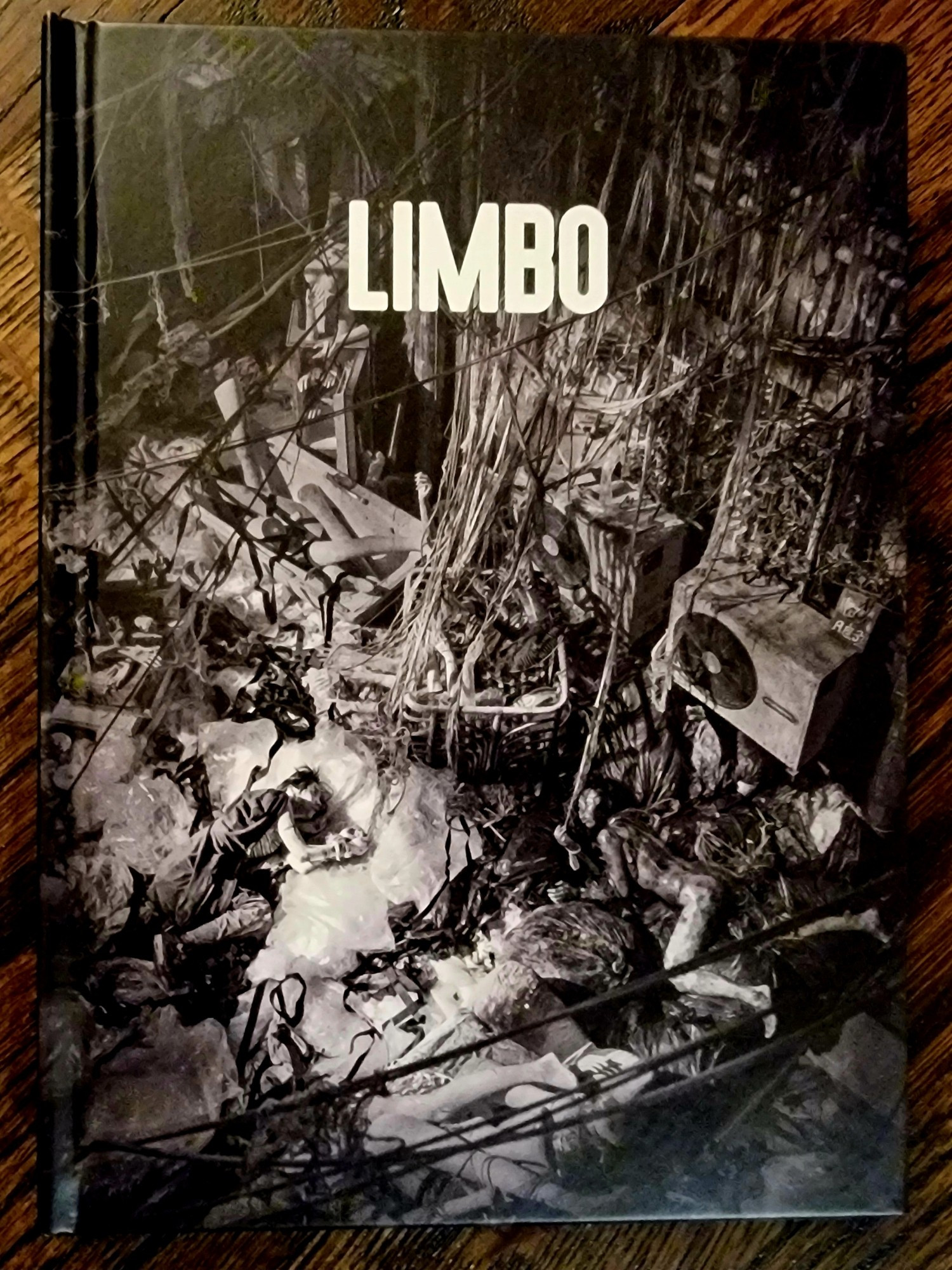 Blu ray cover for the film Limbo. It shows a dystopic image of a street with trash and debris in every inch of space.