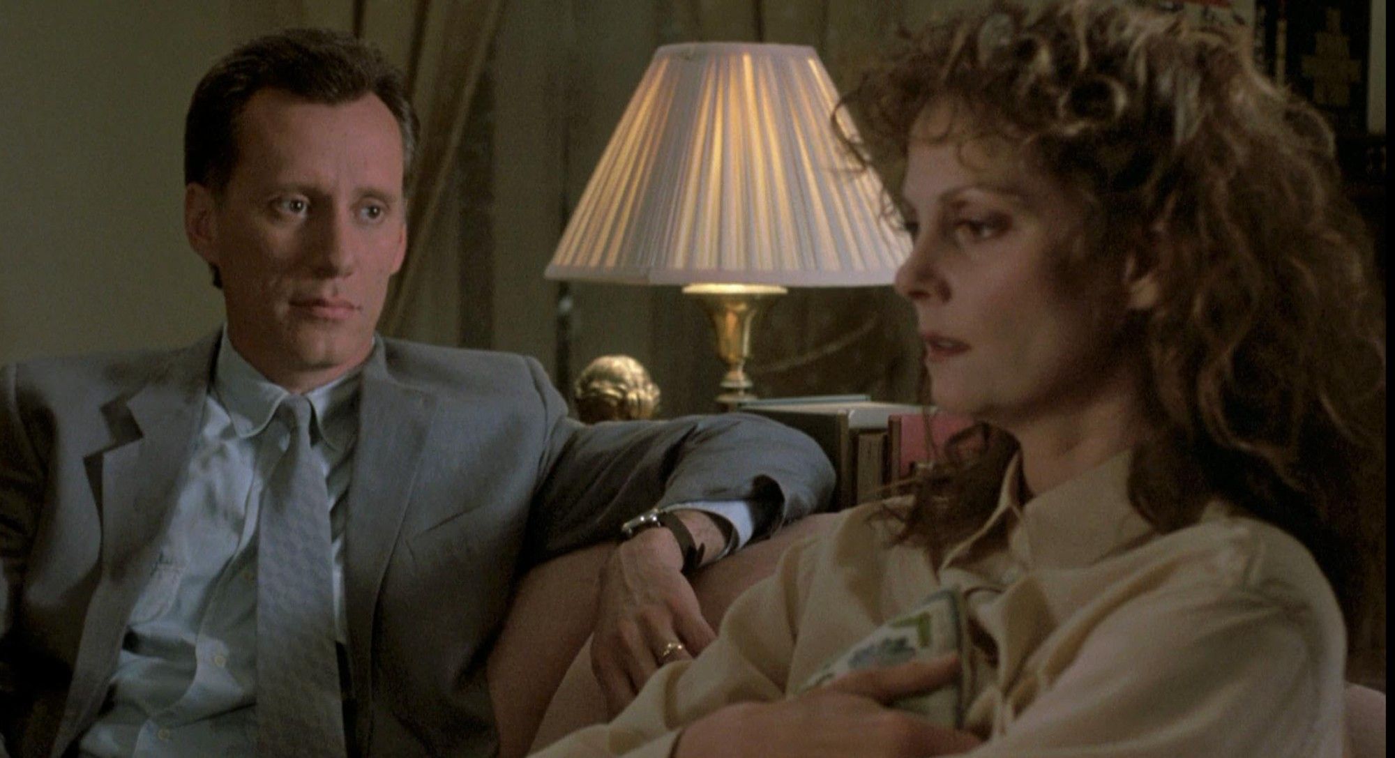 James Woods and Lesley Ann Warren sit on a couch in a still from Cop (1988).