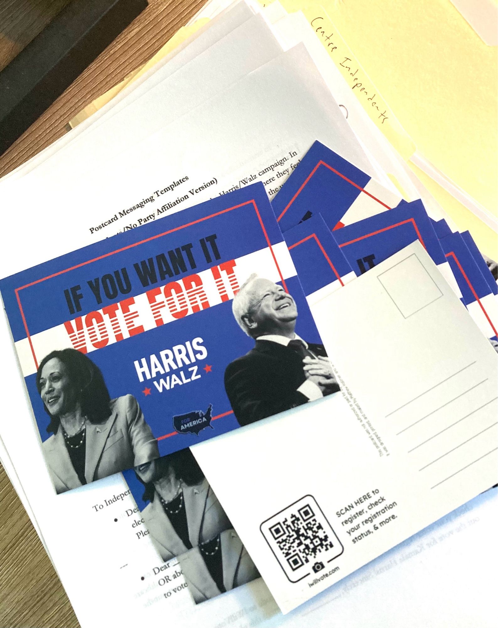 A pile of postcards. On one side, they read “If you want it, vote for it Harris Walz” with an image of both candidates. On the other side, there is a usual postcard layout with space for a message, stamp, and address. There’s also a QR code to iwillvote.com