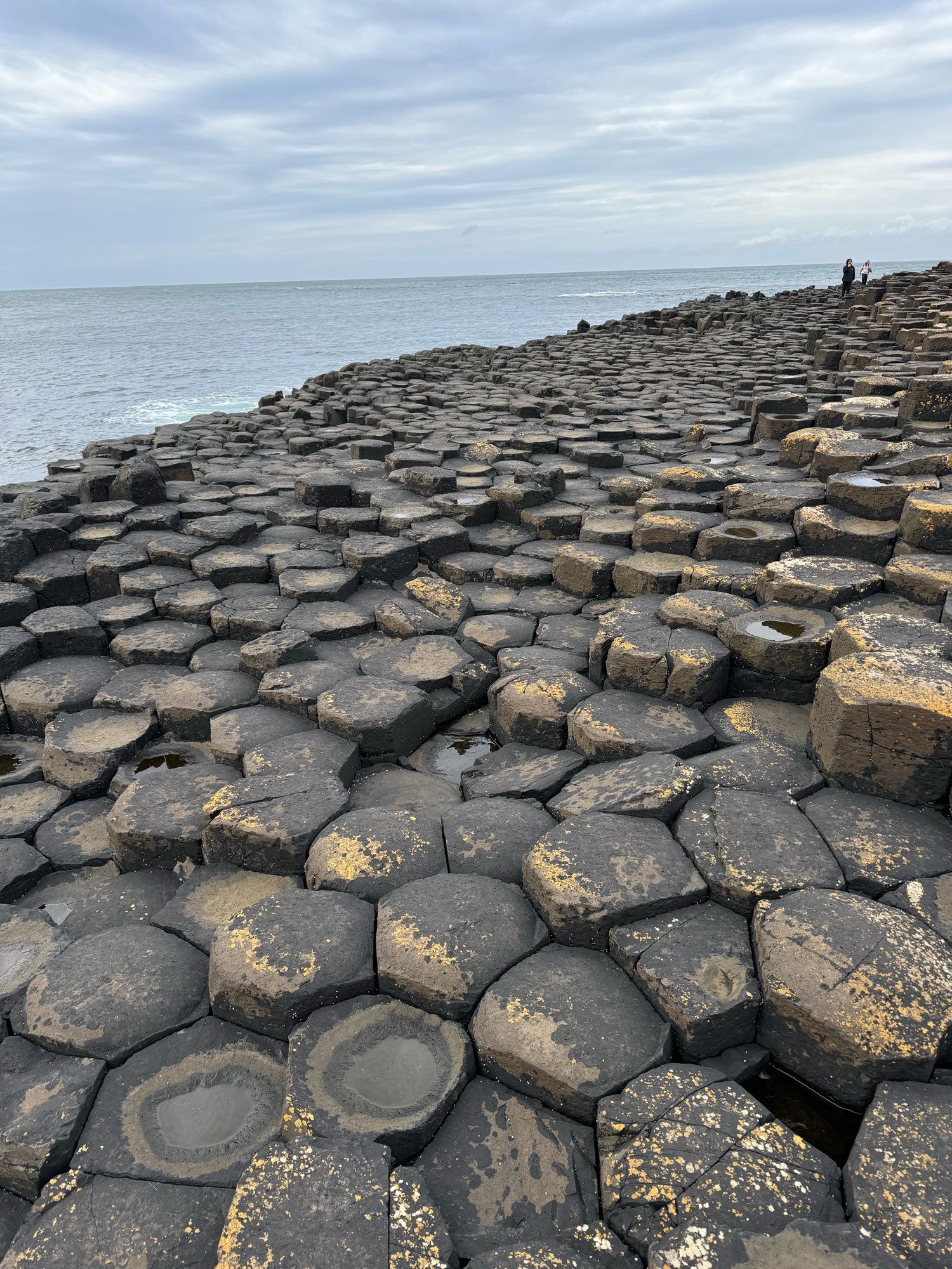 Black basalt pillars by the grey Irish Sea.