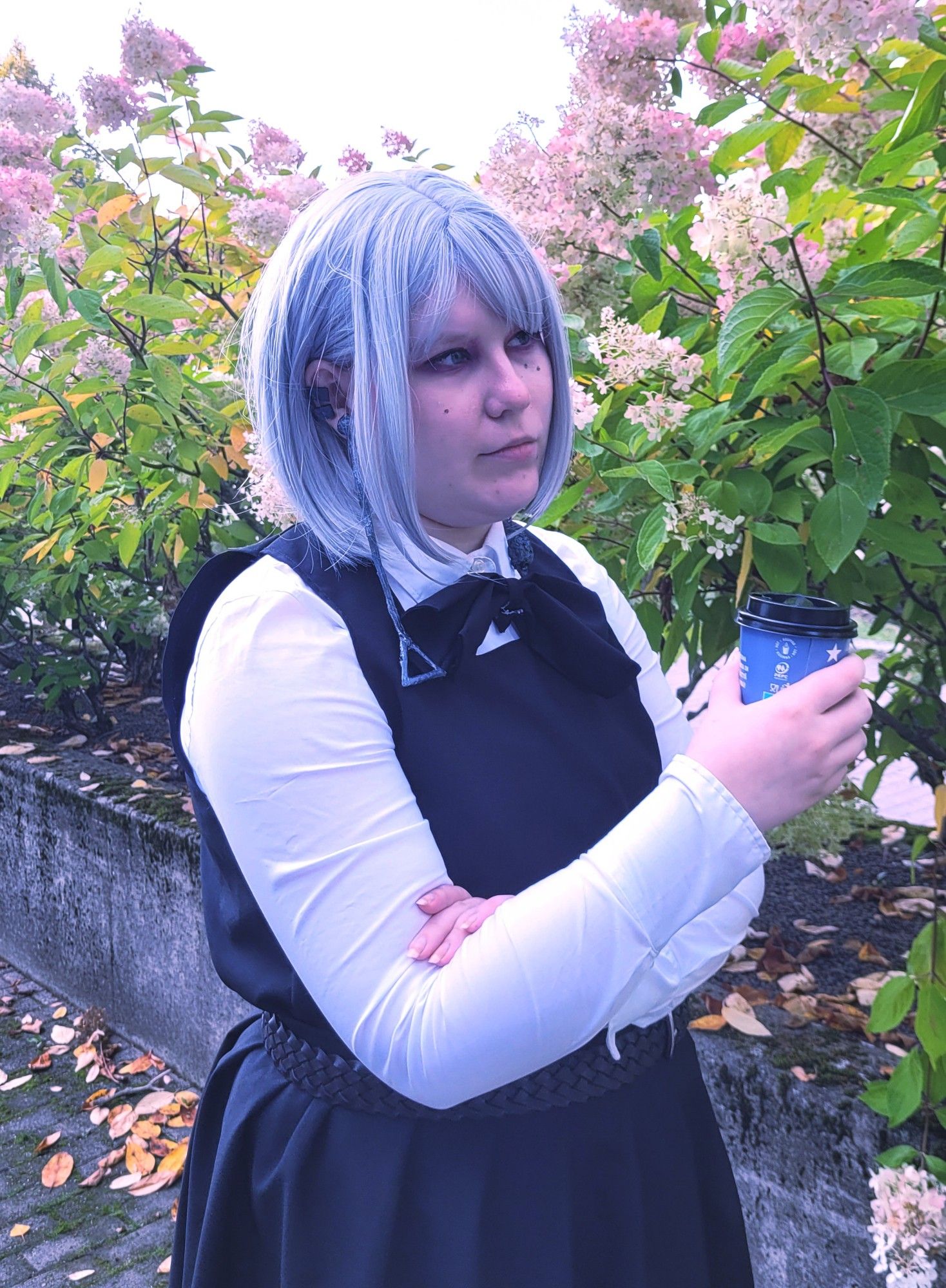 Person in a selfmade Fami cosplay from Chainsaw Man manga. They are holding a to go coffee cup in their hand.