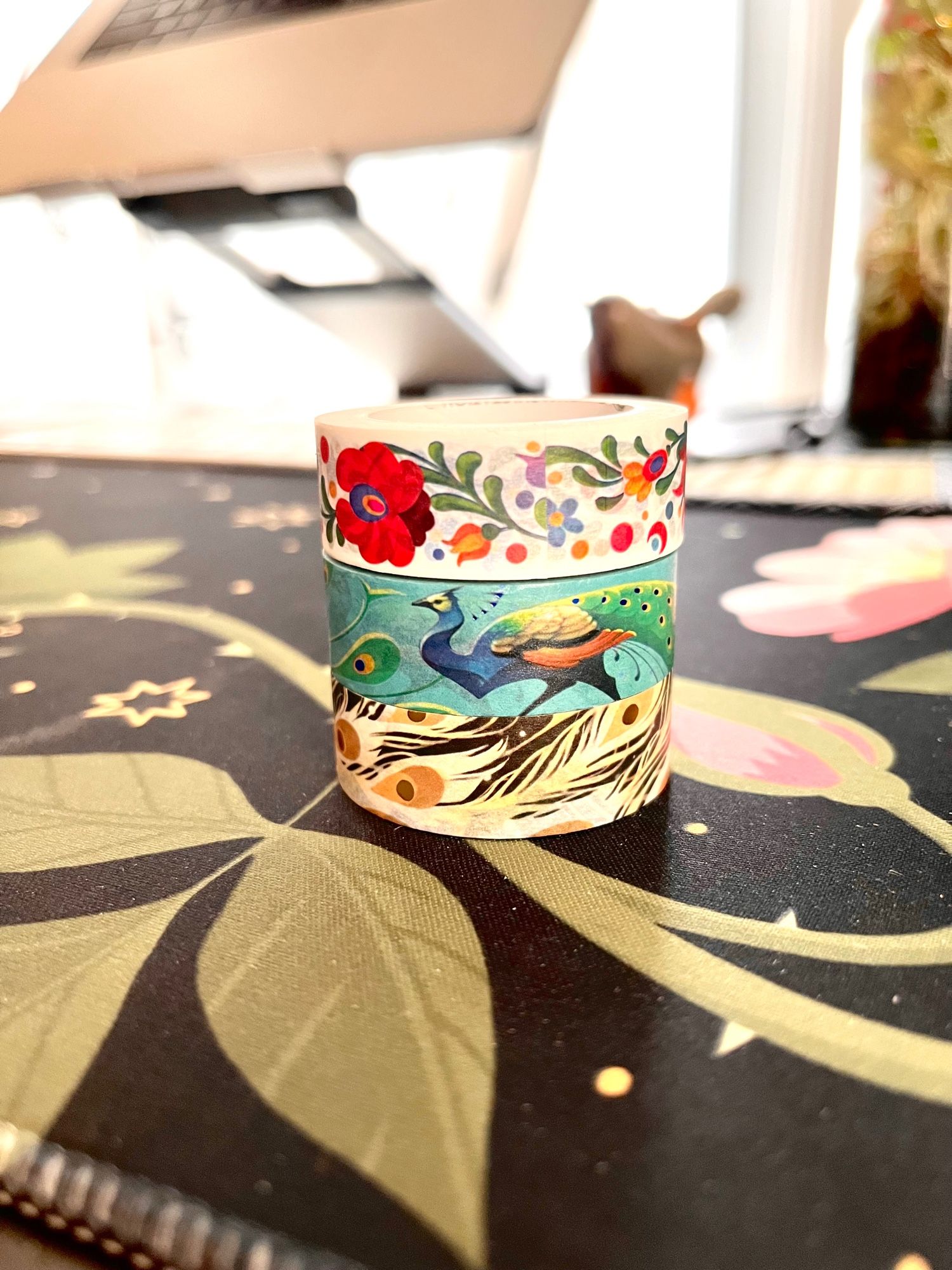 Small stack of washi tape with designs of peacocks and feathers and Hungarian embroidery