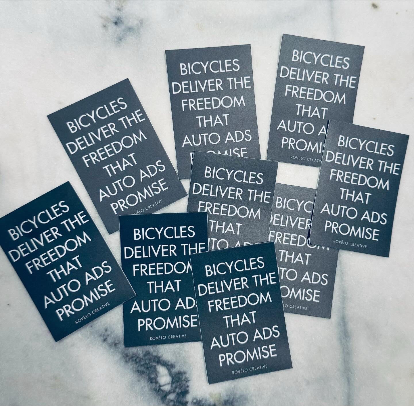 A bunch of black stickers with white type: Bicycles deliver the freedom that auto ads promise