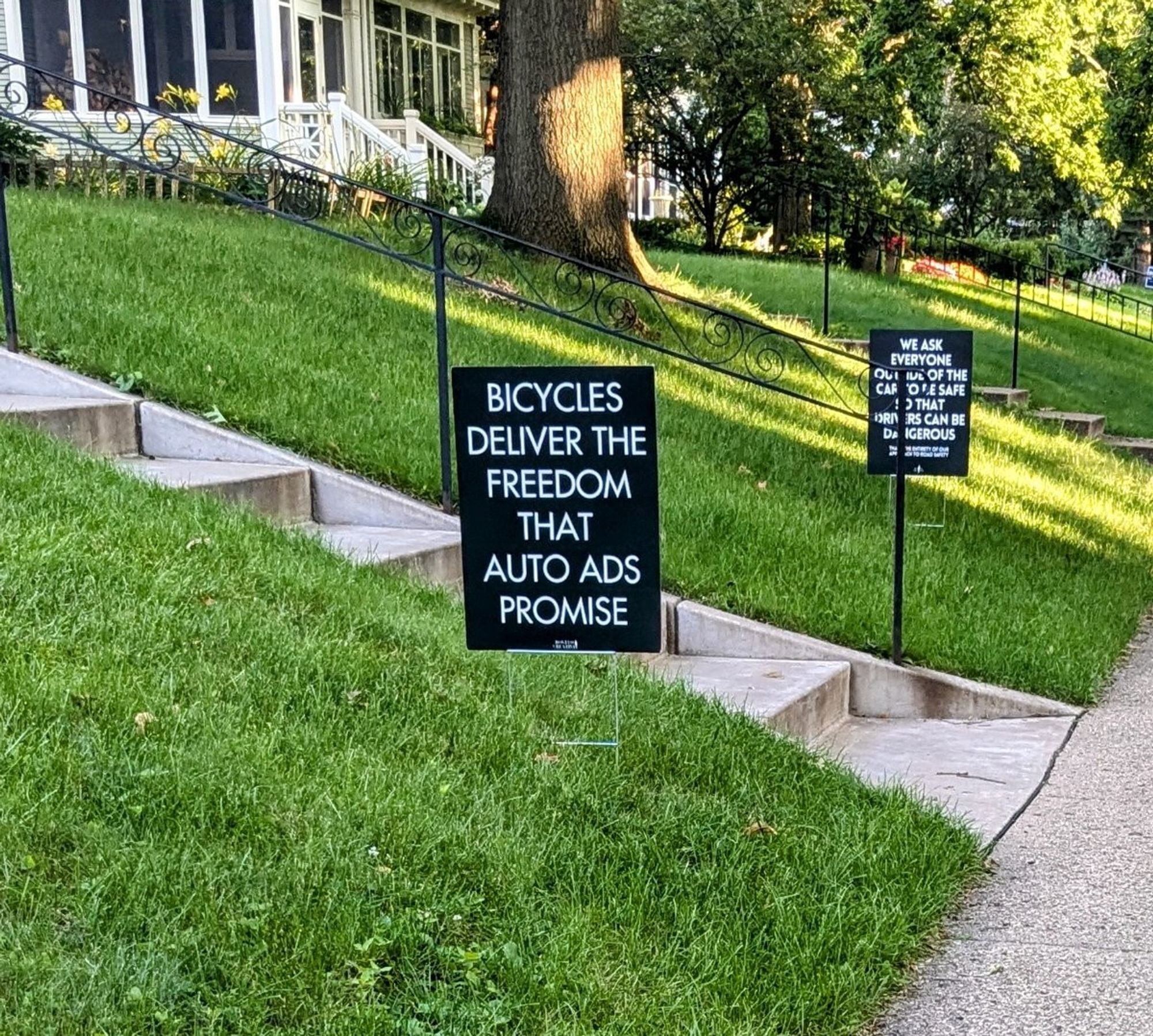 two black yard signs with white tupe
1. Bicycles deliver the freedom that auto ads promise
2. we ask everyone outside of the car to be safe so that drivers can be dangerous