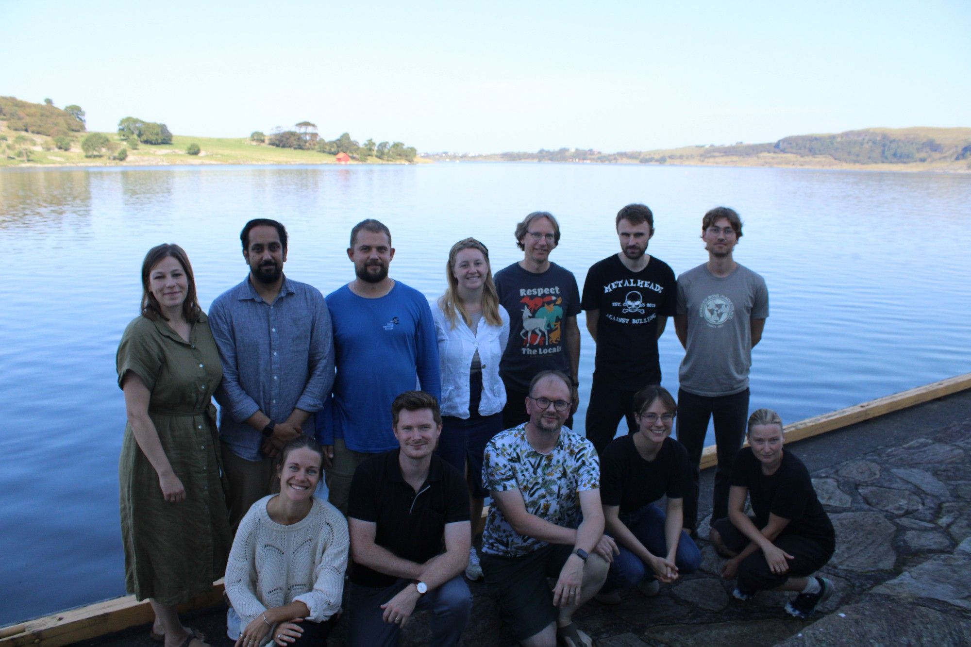 A group picture of 12 Greenhouse scholars in front of a body of water.