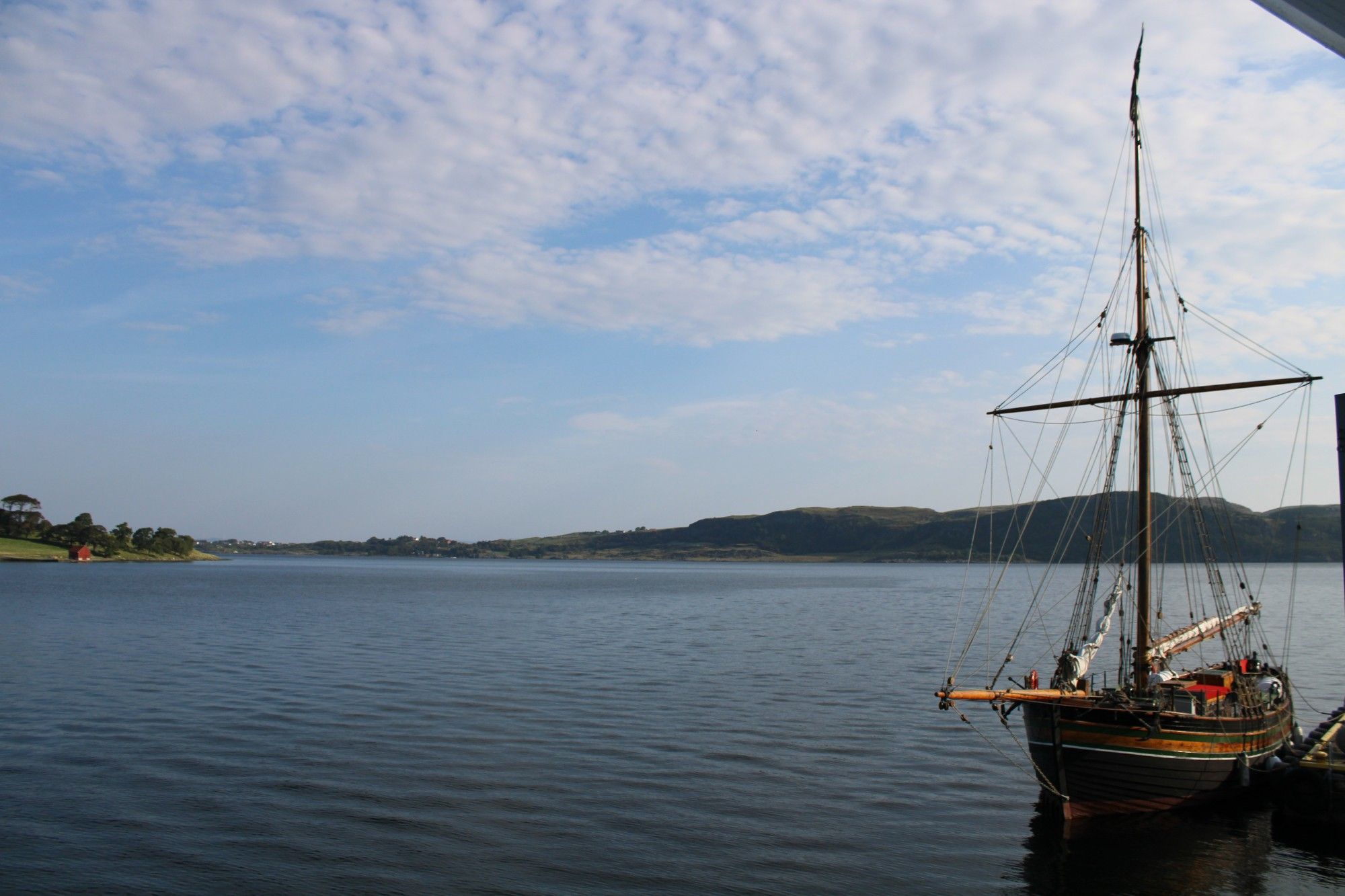 An old-fashioned sail ship on a placid body of water.