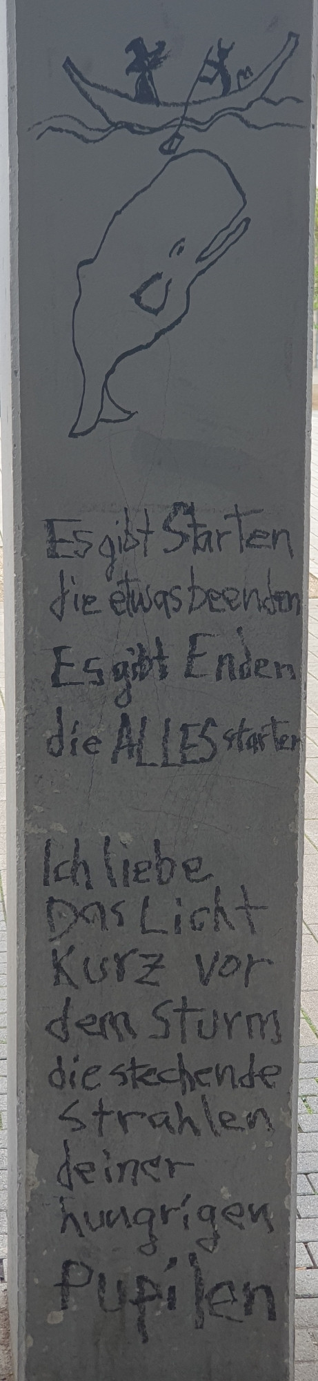 Säule mit Eddingbild. 2 Personen im Boot. Eine rudert. Andere hat einen Hut auf. Unter dem Boot ein Blauwal. Unter diesem der Spruch "Es gibt Starten die etwas beenden. Es gibt Enden die ALLES starten. Ich liebe Das Licht Kurz vor dem Sturm die stechende Strahlen deiner hungrigen Pupilen"