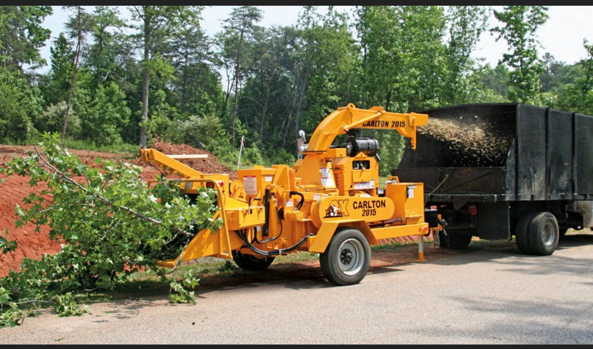 A huge brush chipper satisfyingly turning a huge pile of brush into a small pile of useful mulch