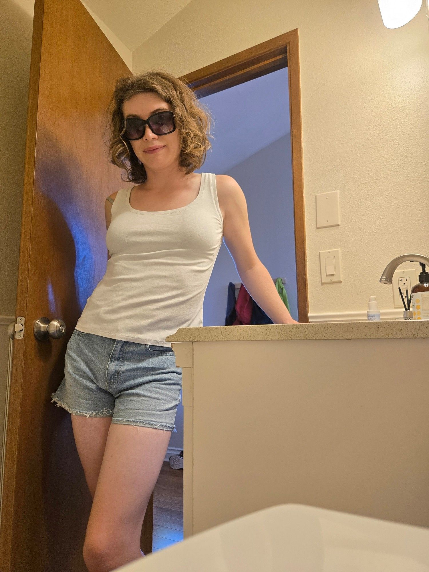 trans girl in white tank and jorts