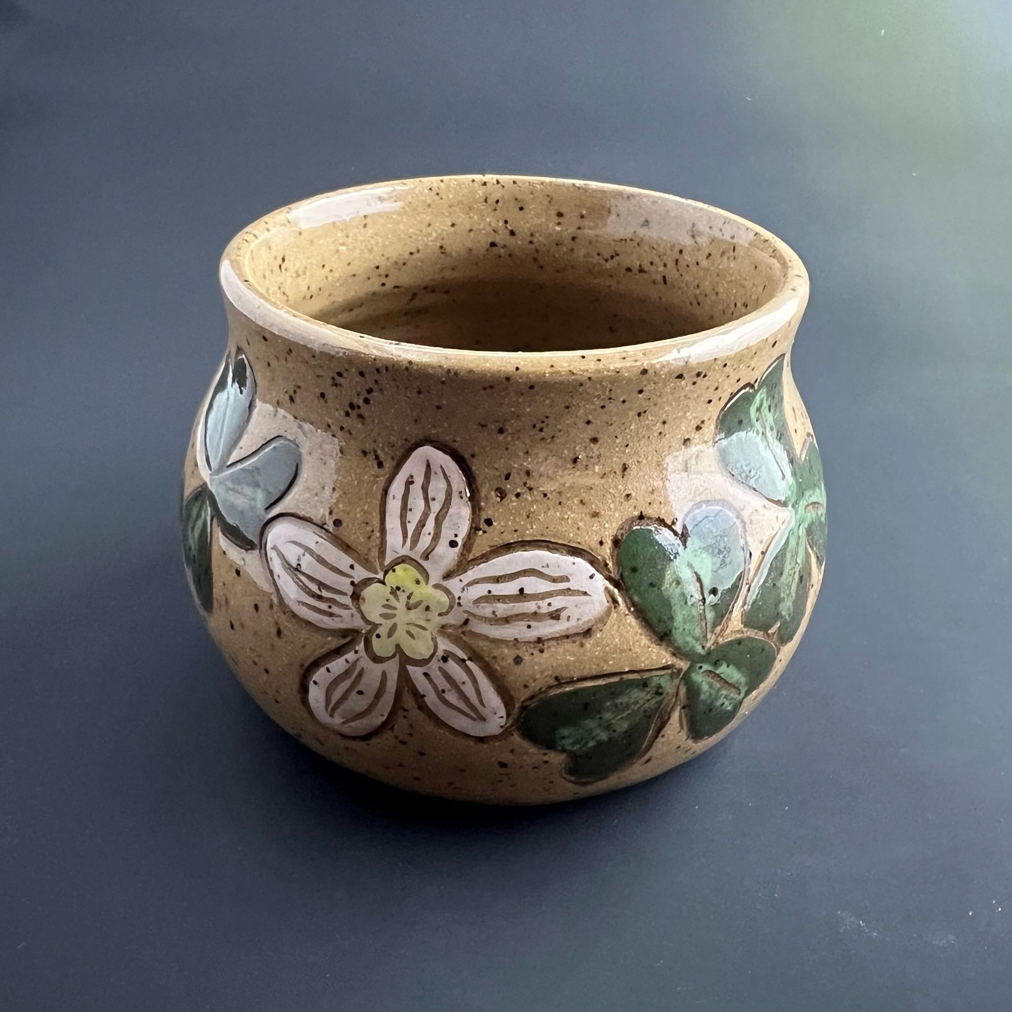 Back side of the vessel with white and yellow flowers and clover shaped sorrel leaves