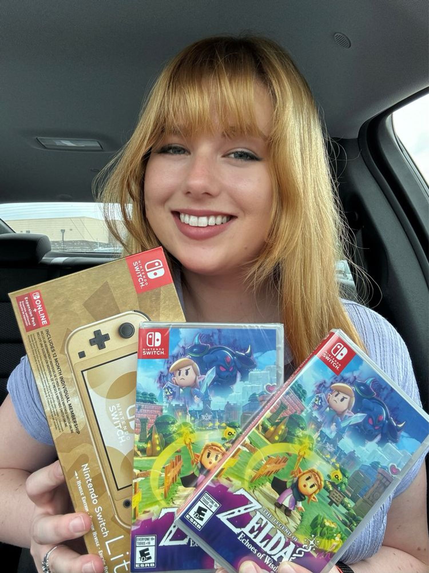 Selfie of me holding 2 copies of Echoes of Wisdom and a gold Zelda Nintendo switch lite box