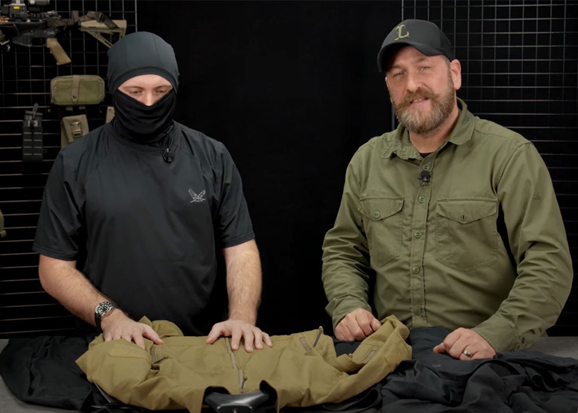 Two men showing clothing from Night Heron