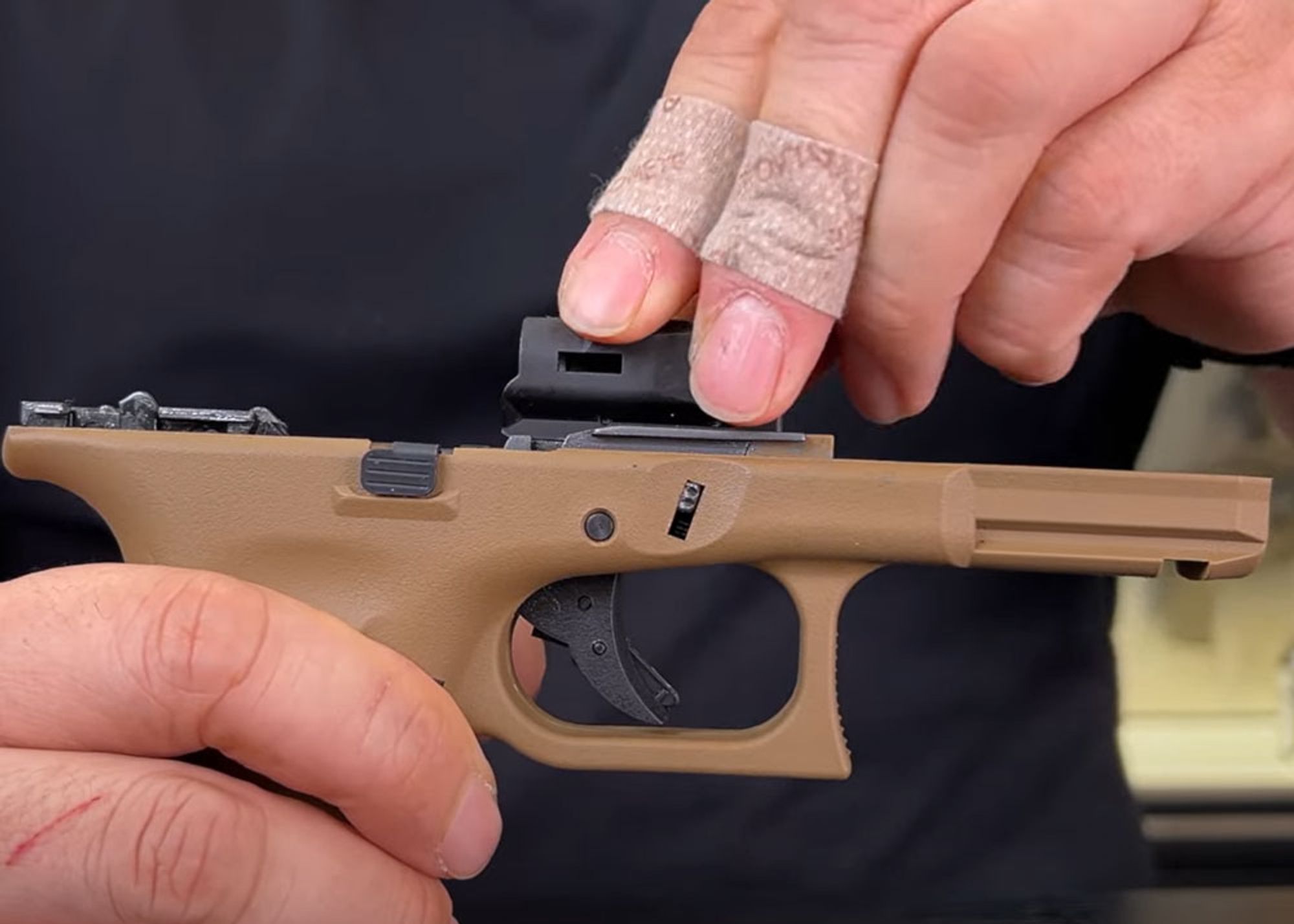 A man installing the AirSix Stainless and PVD Trigger Chassis on a VFC Glock airsoft pistol