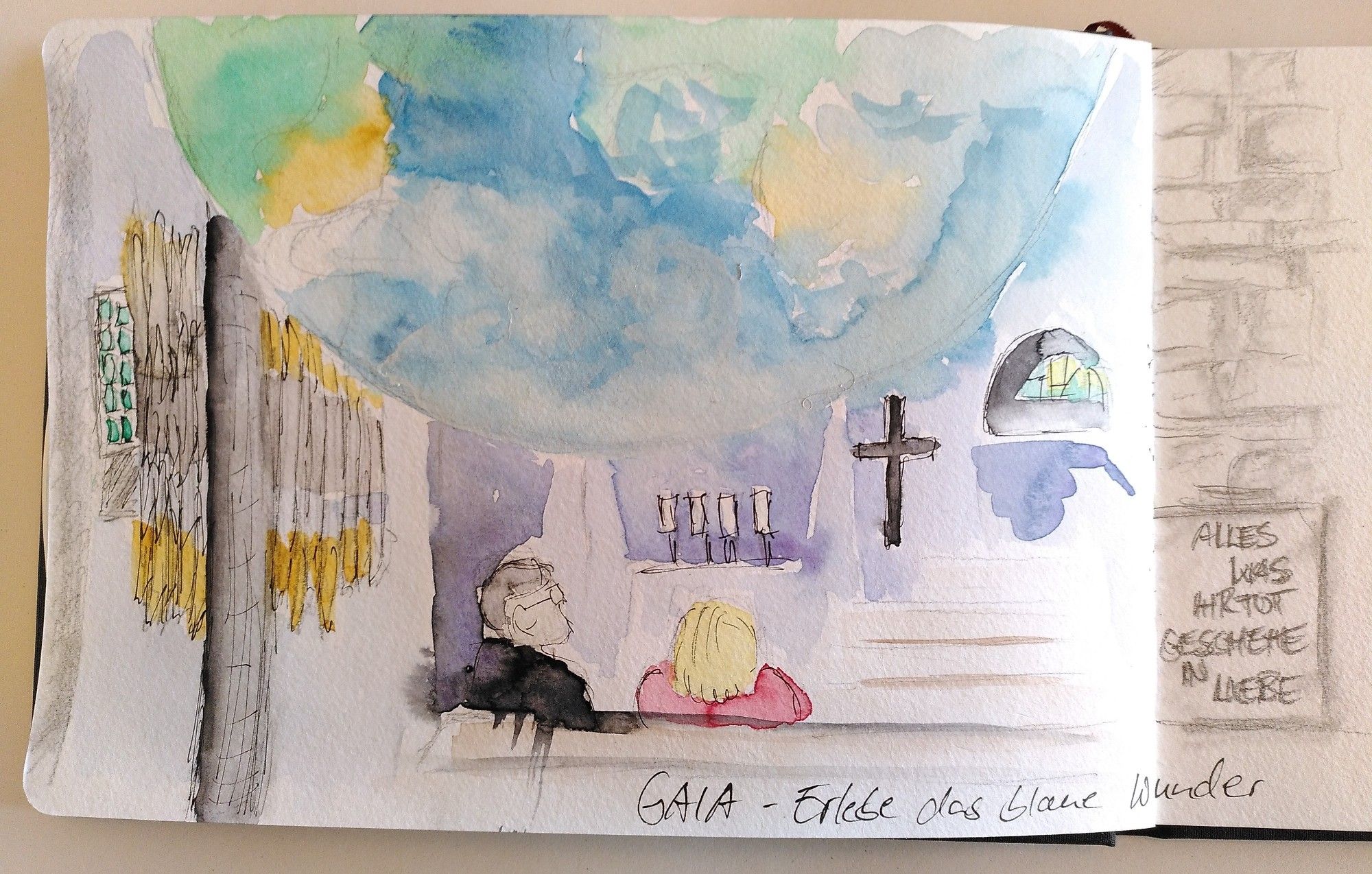 Linke Seite eines aufgeschlagenes Skizzenbuchs. Aquarellzeichnung der unteren Hälfte der Weltkugel. Zwei Personen sitzen in den Kirchenbänken und schauen nach oben. Kerzen, ein Kreuz, Kirchenfenster und an der Wand Orgelpfeifen sind angedeutet. Unten ein Text "GAIA - Erlebe das blaue Wunder". Rechts angedeutet eine Mauer, davor eine Tafel mit dem Text "alles was ihr tut geschehe in Liebe".