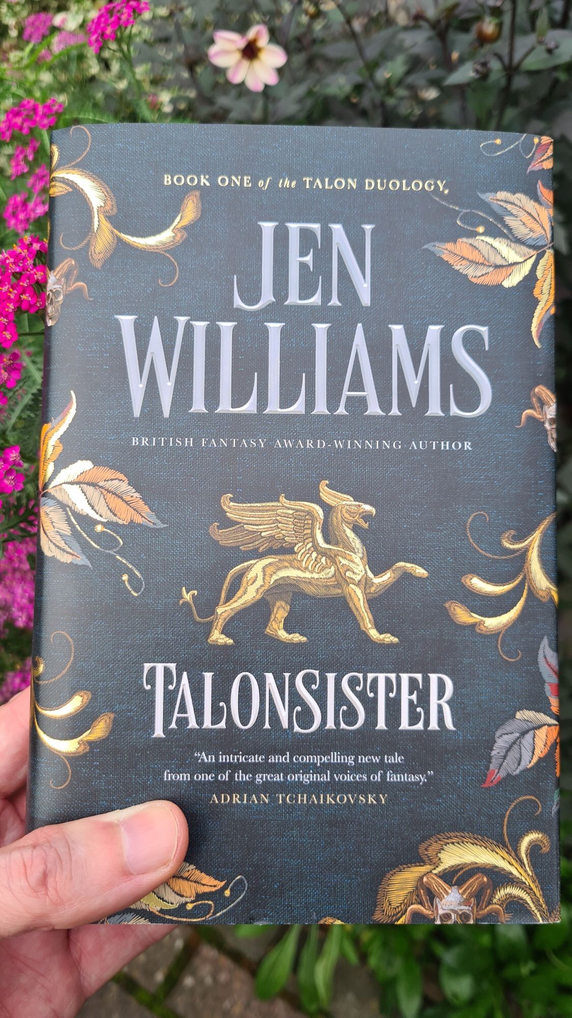 Hand holding the book Talonsister by Jen Williams