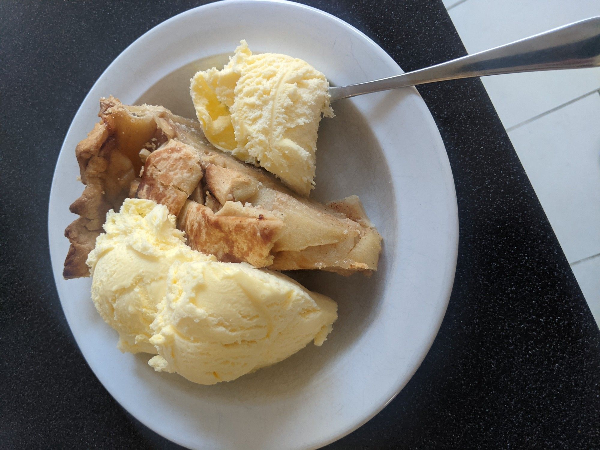 Slice of homemade apple pie with a generous portion of Cornish Cream ice cream