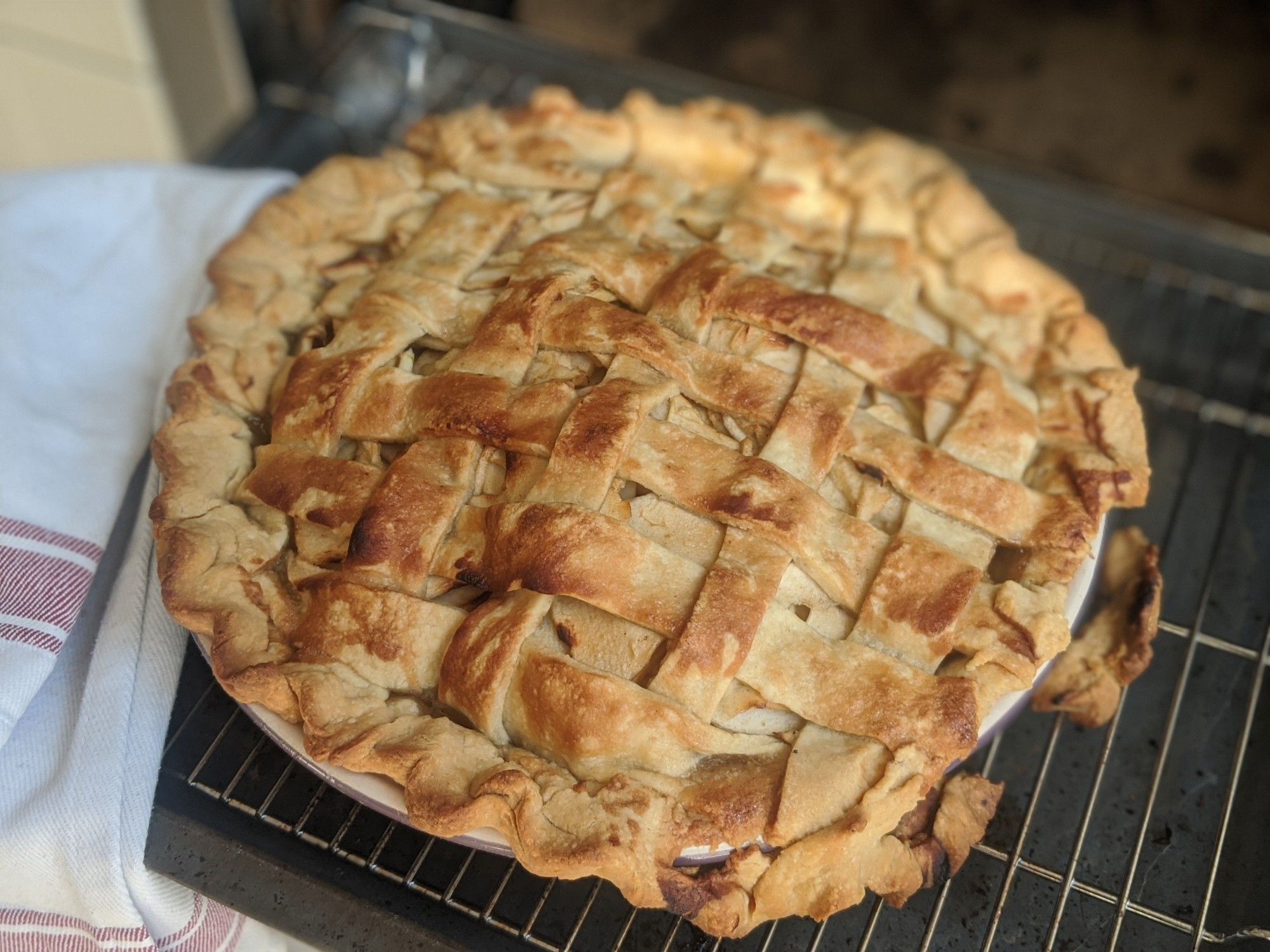 Home made apple pie with a lattice crust top, but some of the rim crust broken off