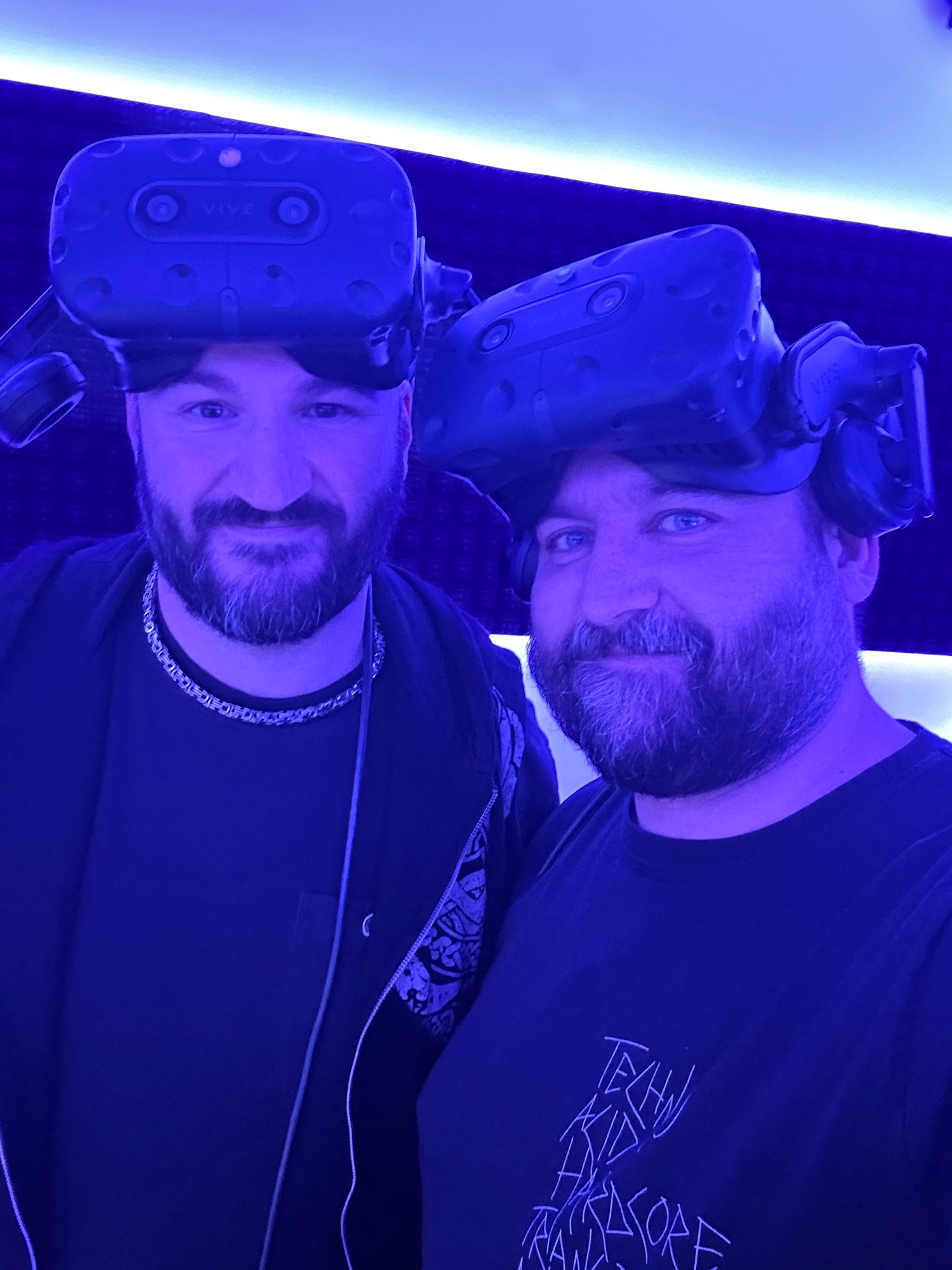 Selfie of two bearded guys in their early fourties. The left guy on the picture is bald, the guy on the right side with a buzz cut. Both have VR headsets on their heads.