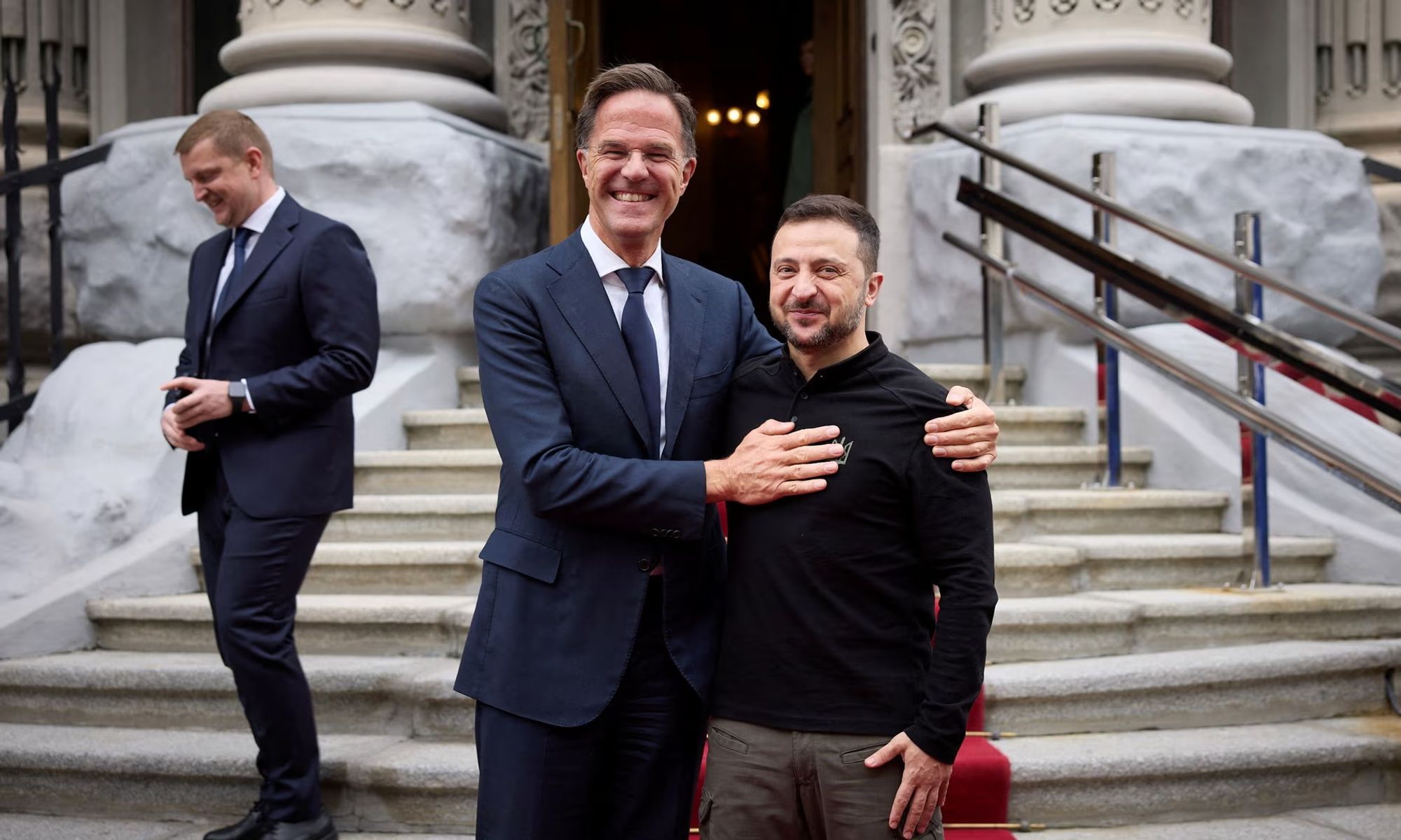 An image of Nato secretary general, Mark Rutte, with a big smile touching the breast of the Ukrainian president's, Volodymyr Zelenskyy.