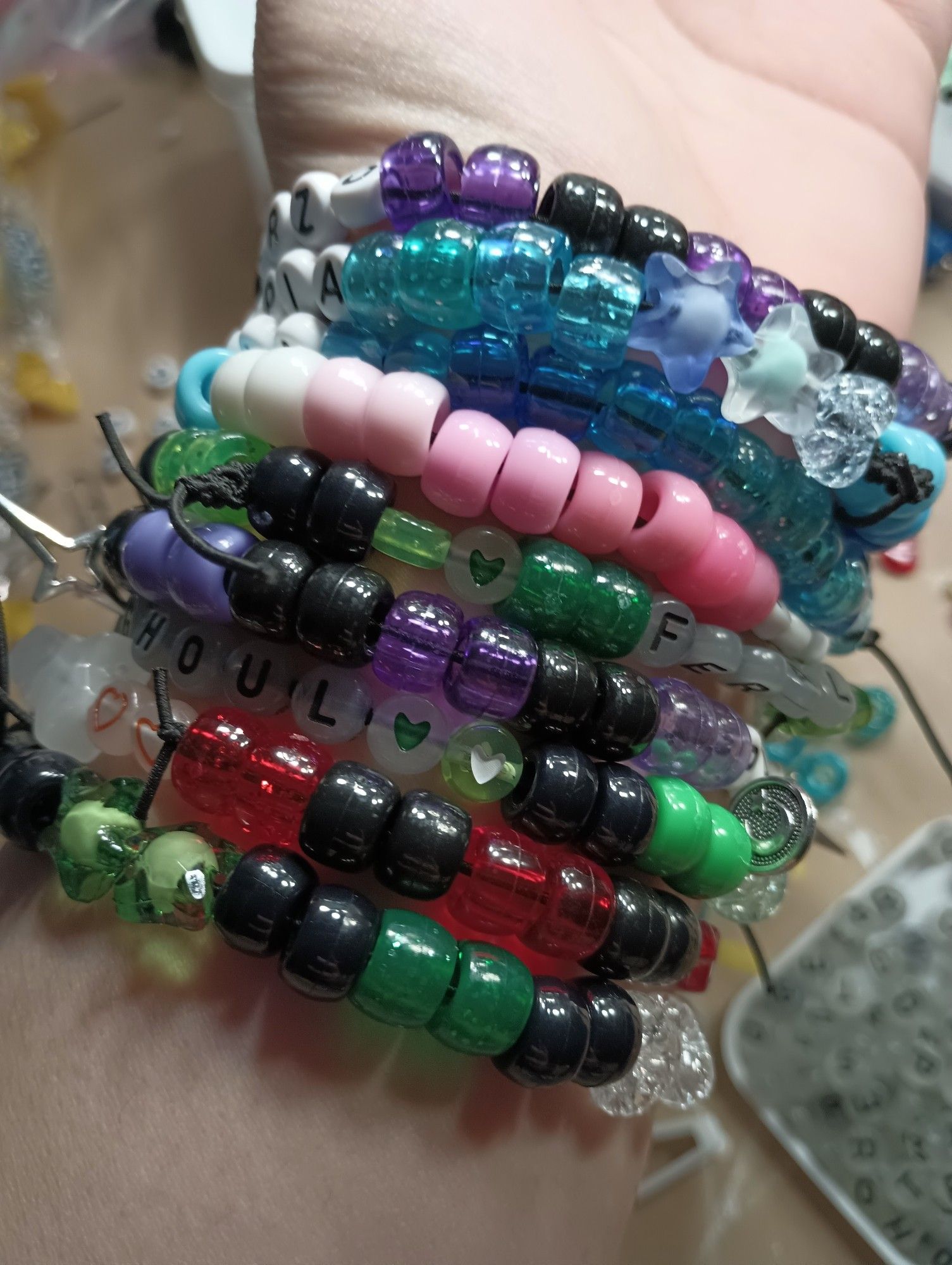 A lot of green kandi bracelets and some purple and blue and a transflag