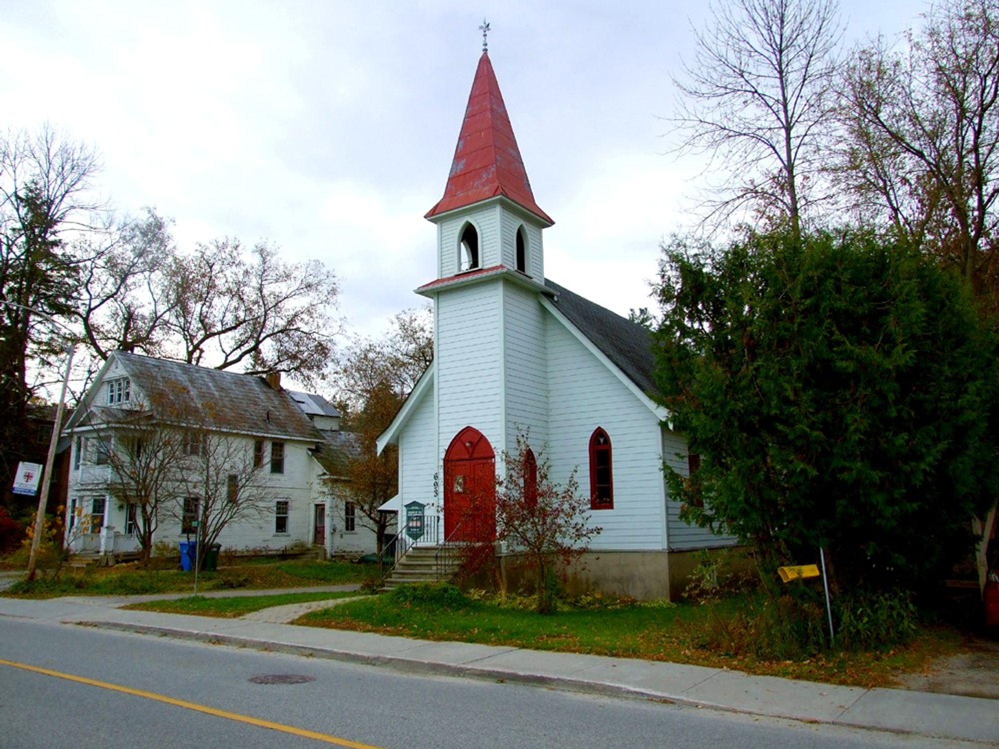 The white church with the red door and red steeple in its sleepy place in the village.