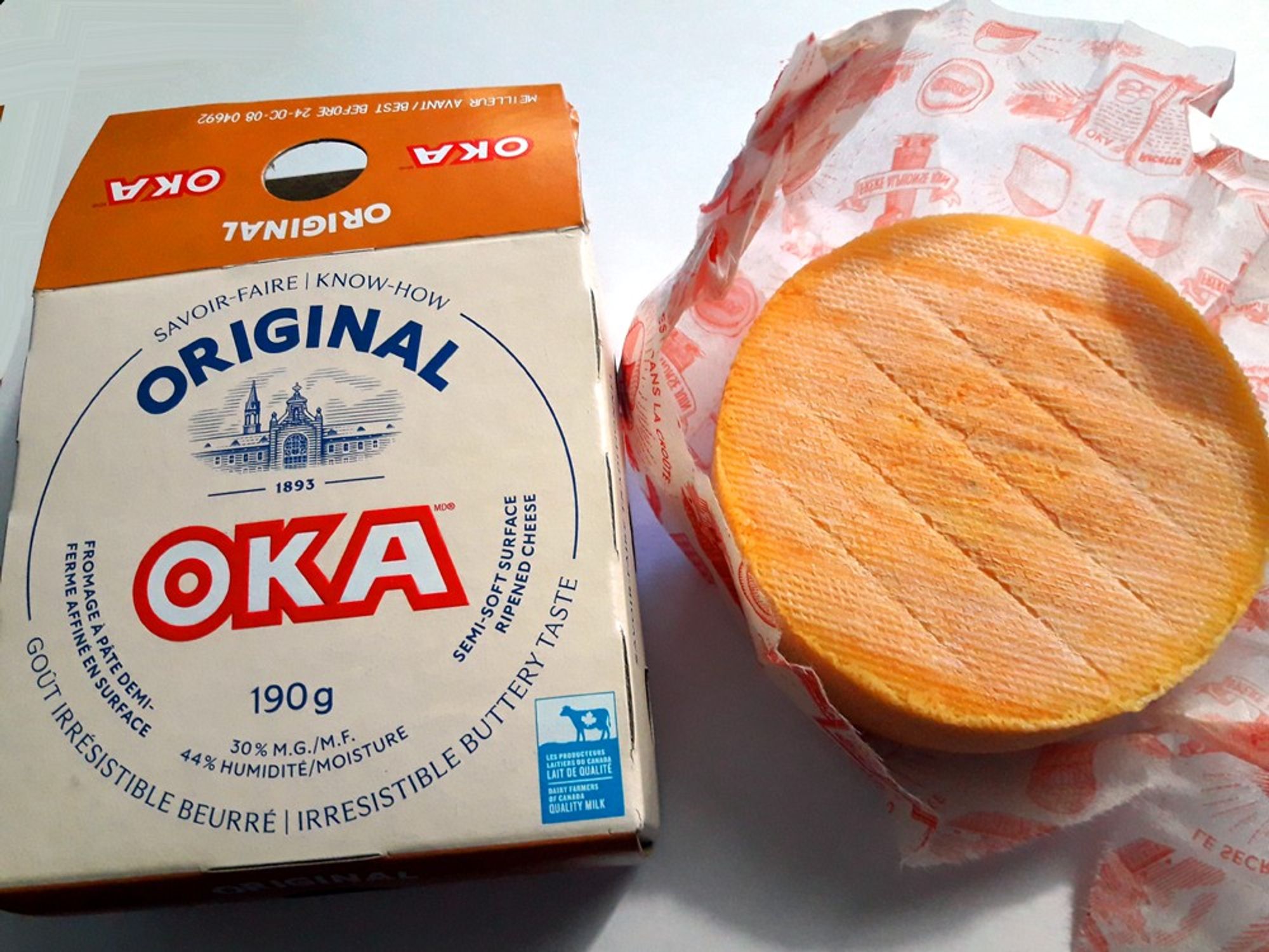 A small wheel of historically famous OKA cheese. It is perhaps Canada's most globally famous cheese. It has thick yellow rind which is edible.