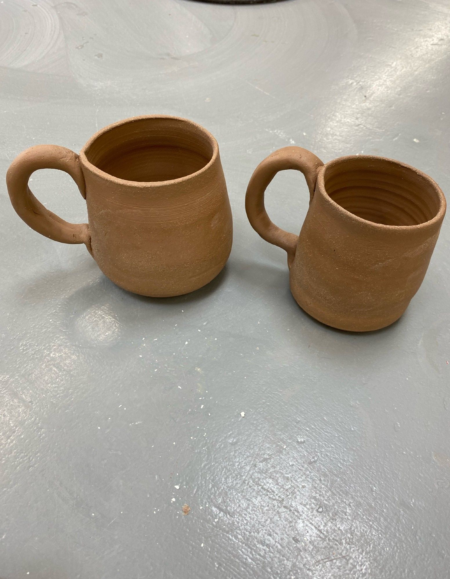 two wheelthrown clay mugs