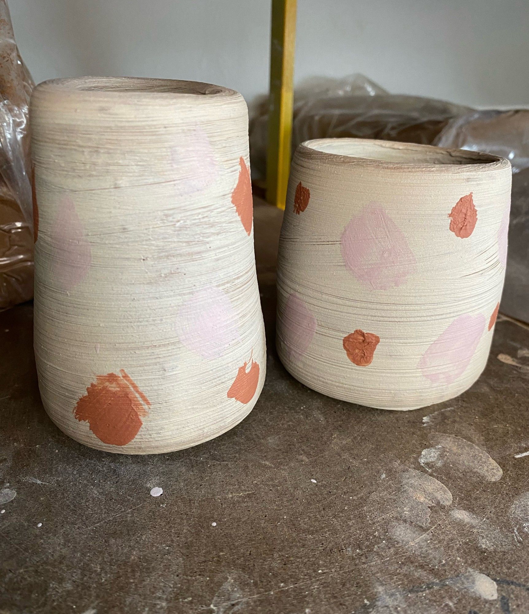 two wheelthrown clay cups with decorations