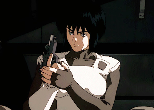 Major Motoko Kusanagi from the first ghost in the shell movie, in armor pointing her pistol at the viewer flicking the slide forward so it is ready to fire. 