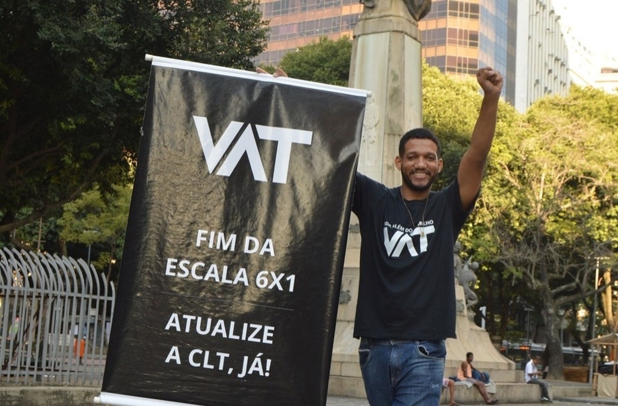 Rick Azevedo levantando um banner escrito VAT, fim da escala 6x1, atualize a CLT já