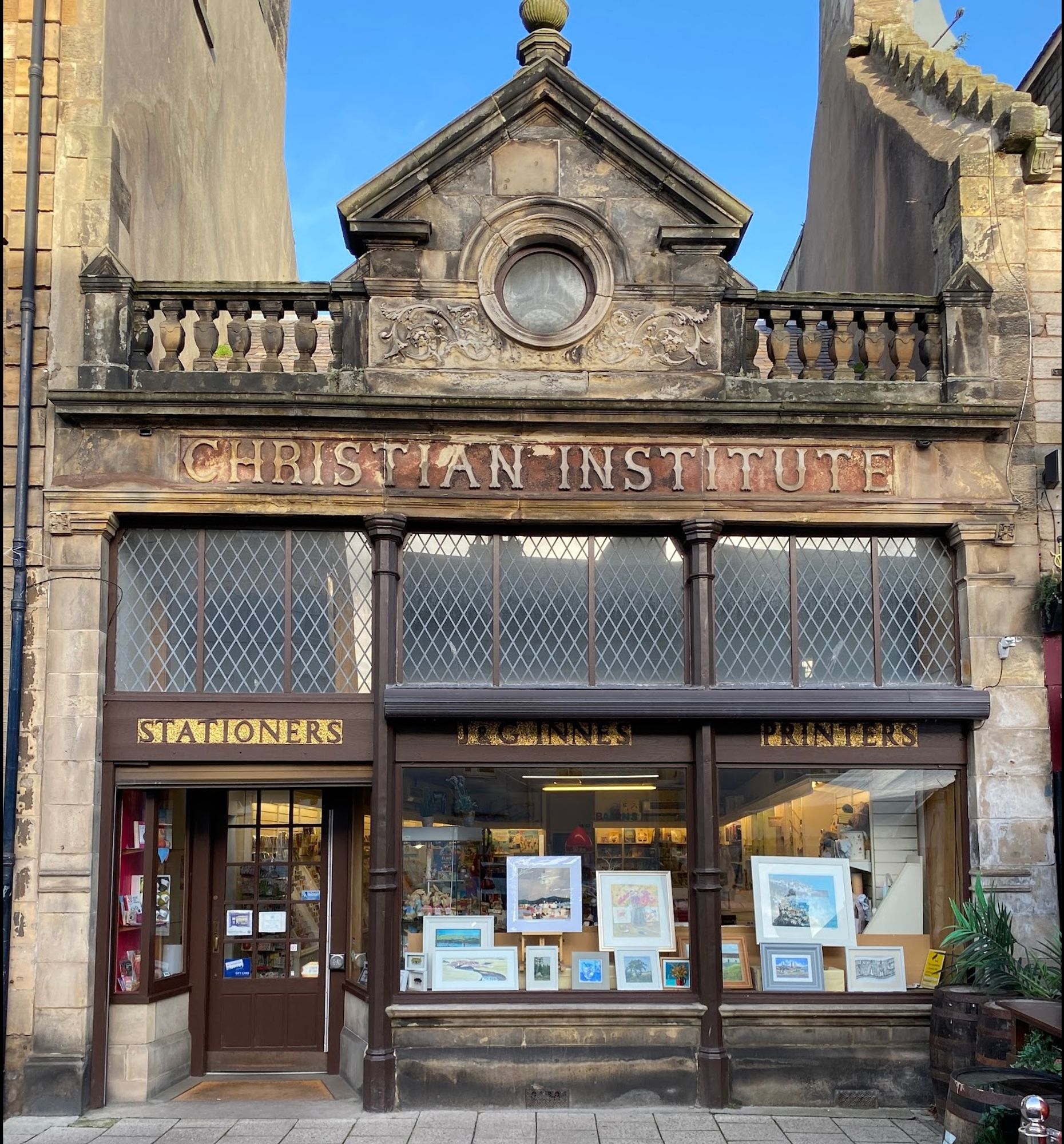 J & G Innes shop expanded into the next-door single-storey building: the Christian Institute inscribed on the frieze.  The three-bay building has a balustrade with a central gable treated as a broken pediment with an oculus and carved scroll decoration, the shopfront has leaded clerestorey lighting, iron columns, recessed doorway.