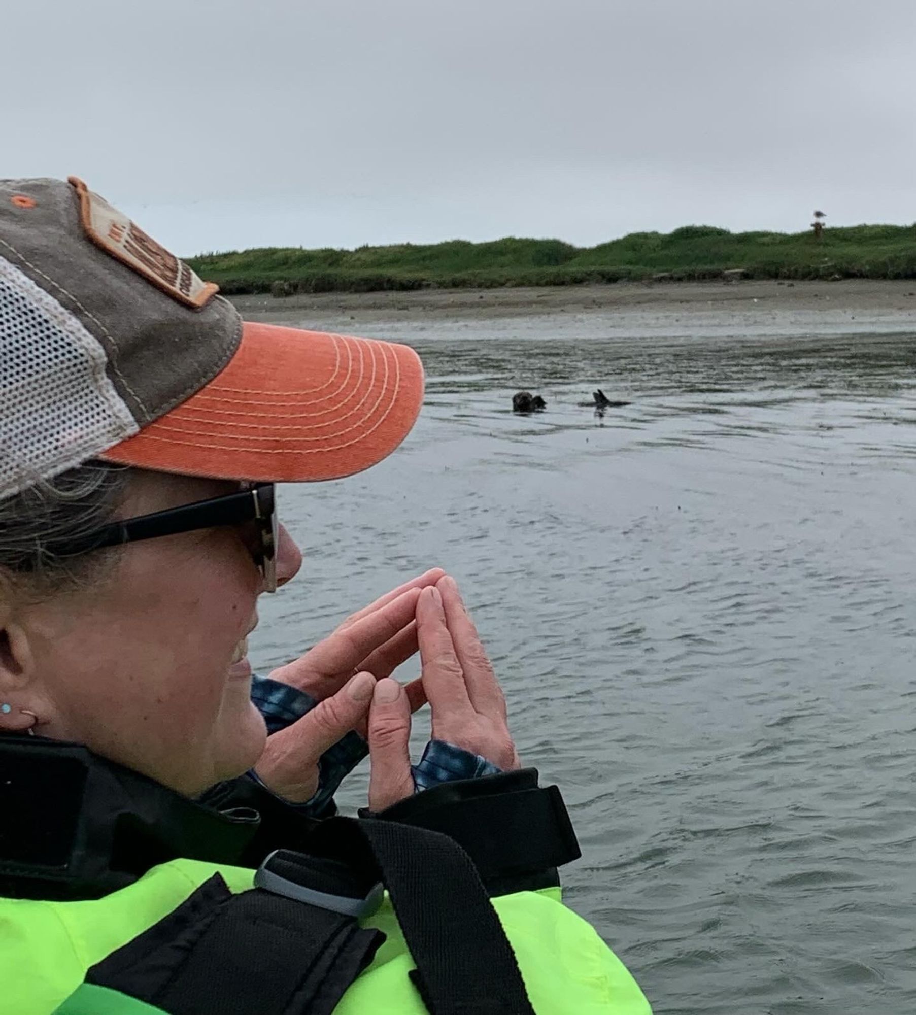 Post author in the front of a kayak mimicking sea otters in the Elkhorn Slough.