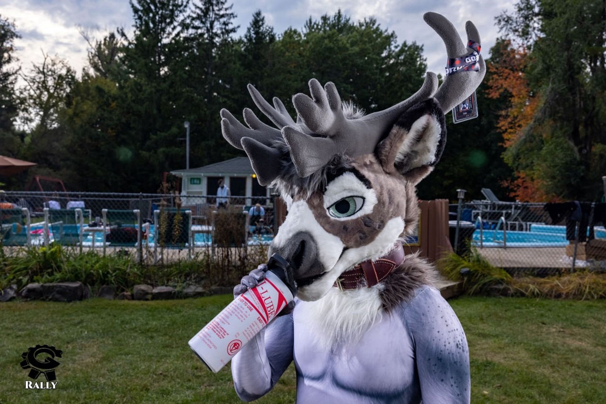 Person wearing reindeer fursuit head drinking from a water bottle that looks like a bottle of J-Lube.