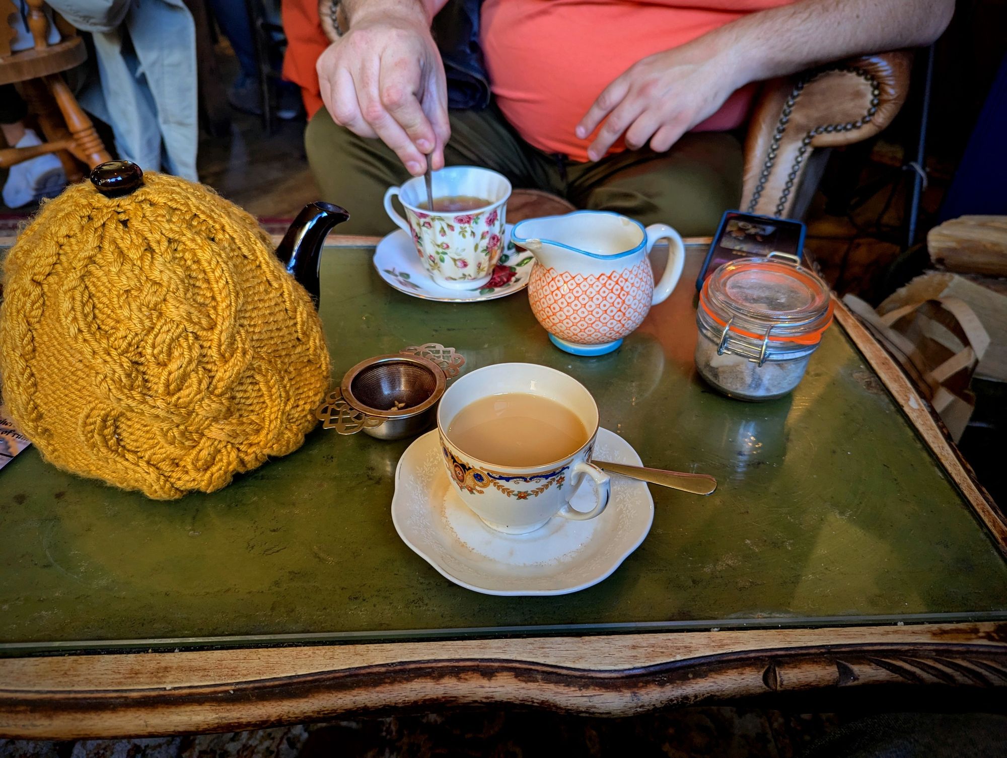 A mismatched rustic teaset on a coffee table.