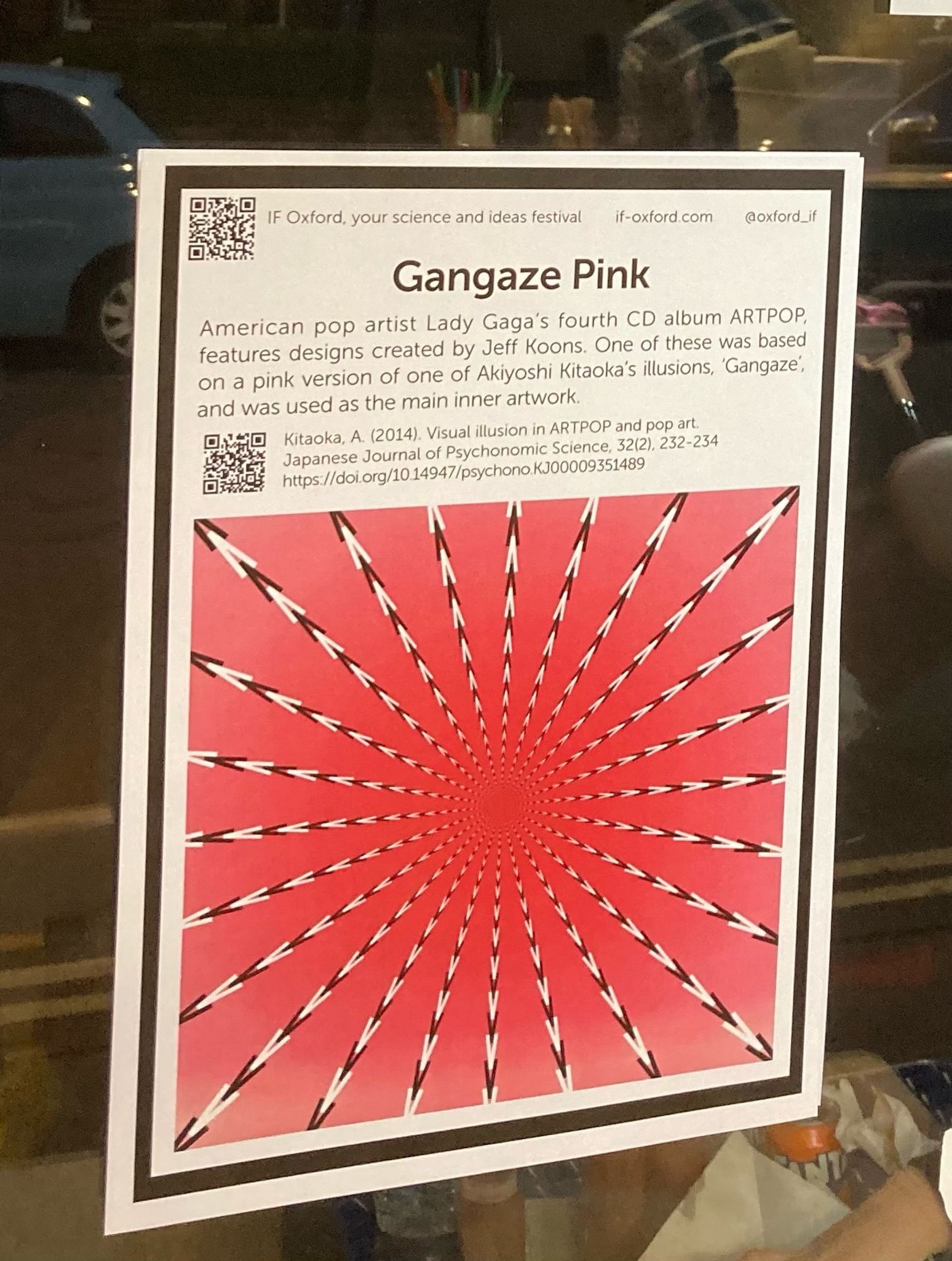 Photograph of an optical illusion/dynamic design printed on a poster. These designs have been used to decorate Uchiwa fans, and can be found at venues across Oxford this month