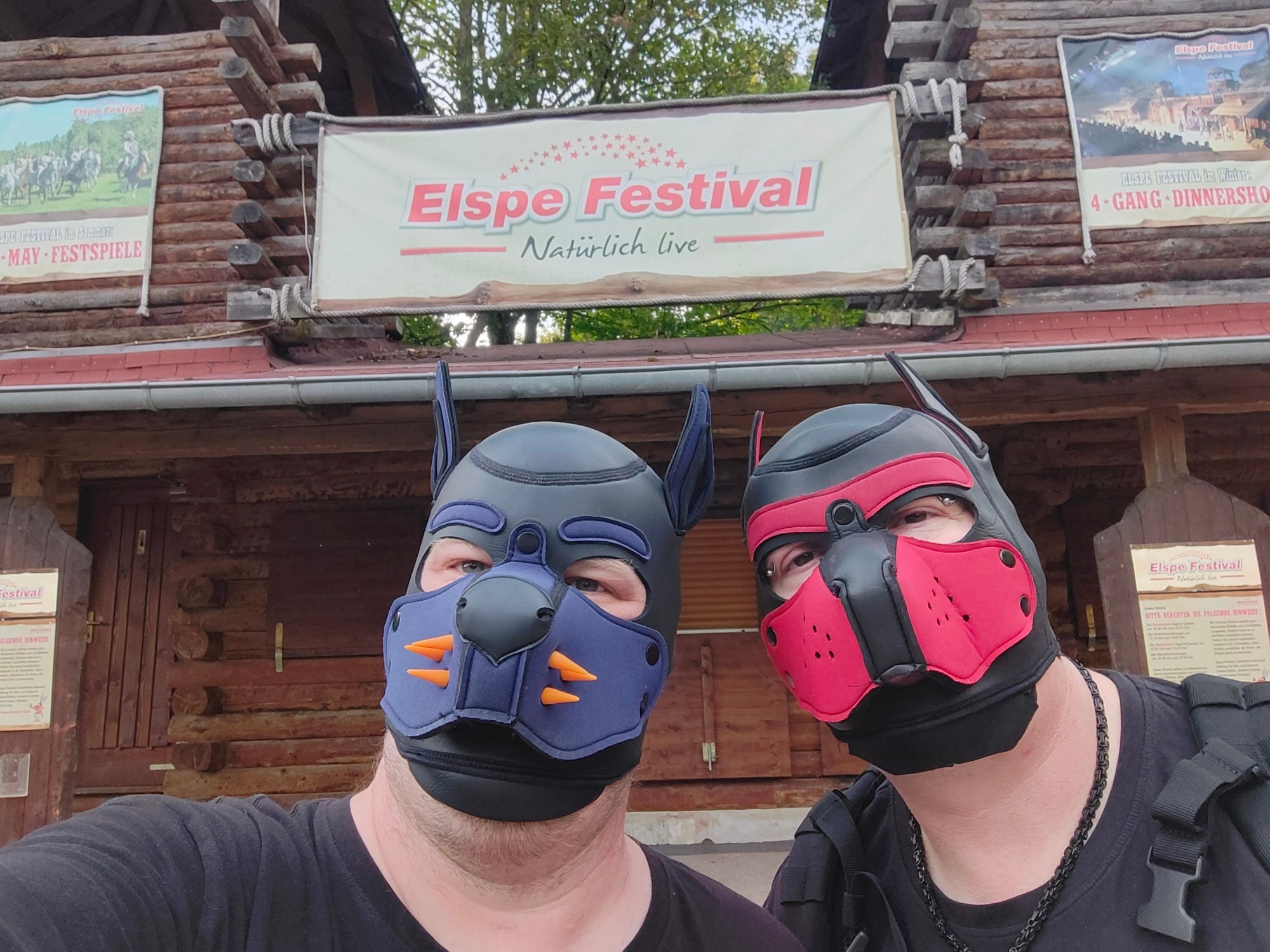 picture of two human pups in front of a sign "Elspe Festival - natürlich live" (naturally live)