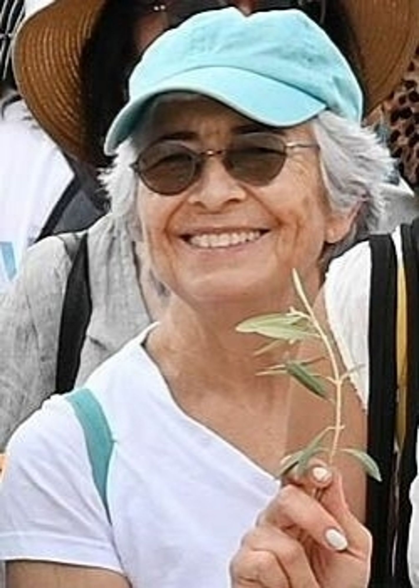 Foto von Vivian Silver mit einem Olivenzweig in der Hand.