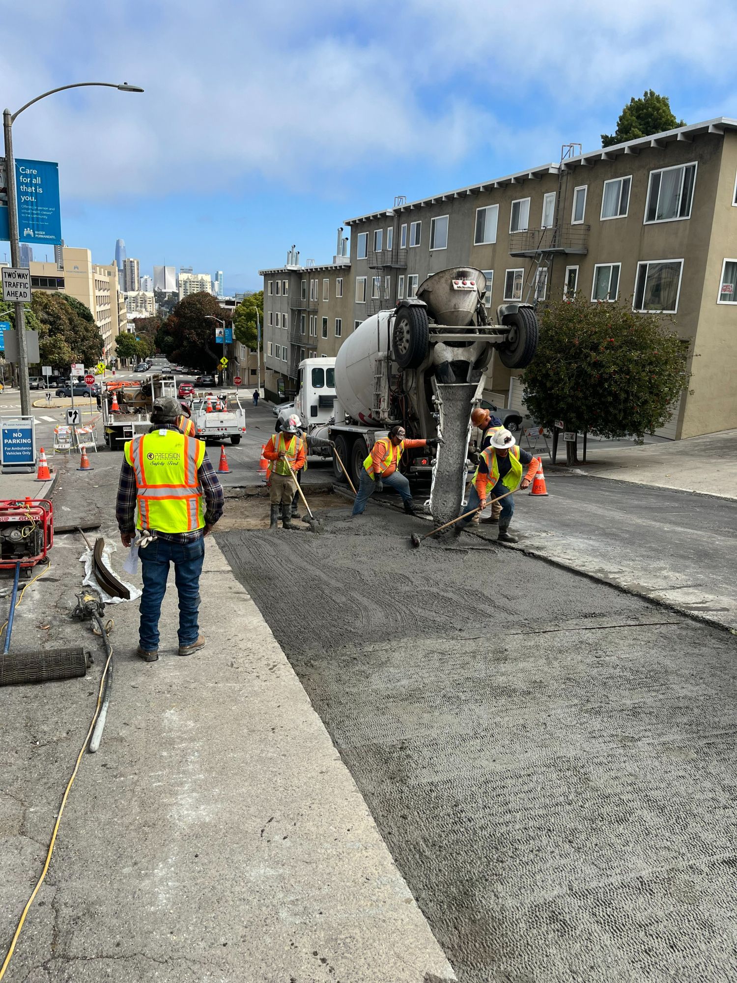 Crews pour fresh concrete on O’Farrell Street, part of the street resurfacing process.