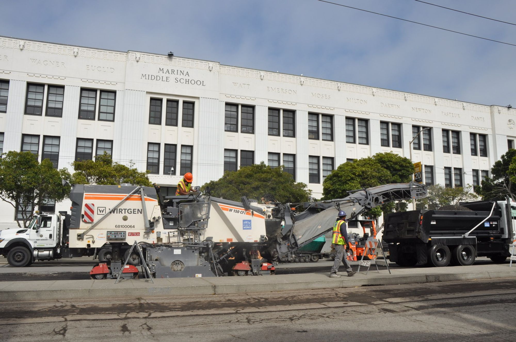 Crews hustle to wrap up the paving job before Marina Middle School students return to classes after summer break.