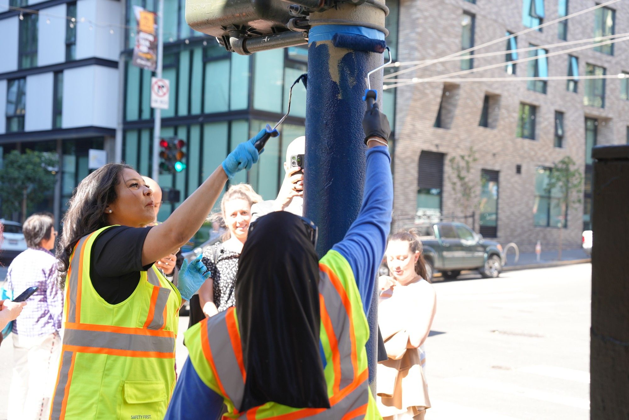 Mayor London Breed and Public Works staff wipe out tags on a light pole in the Tenderloin during a graffiti blitz on Friday, Oct. 4, 2024. Dozens of community volunteers and cleaning crews from Public Works and the Tenderloin Community Benefit District worked together to vanquish graffiti tags from public and private property in the Tenderloin.