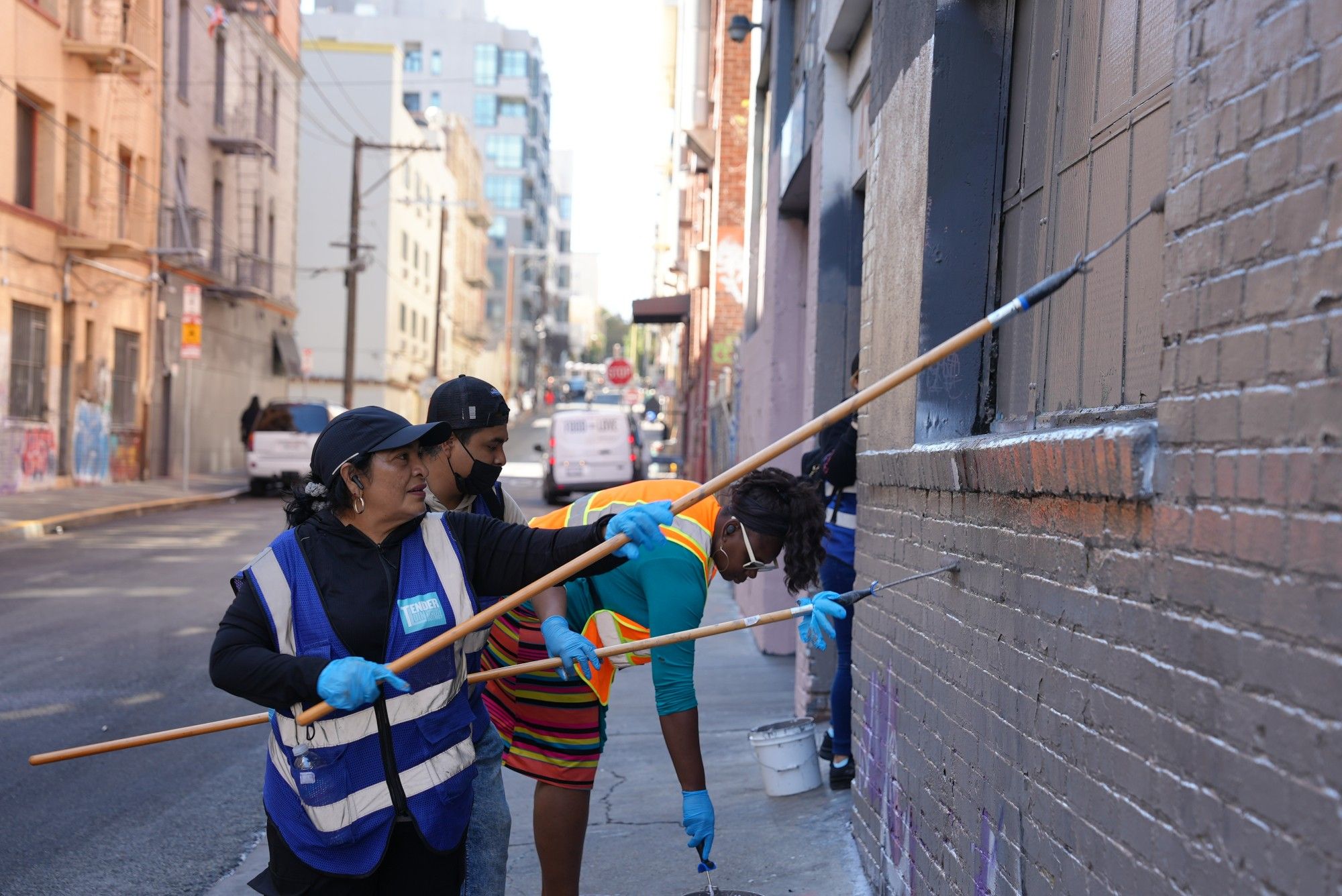 A group of participants wipes out tags on a wall in the Tenderloin during a graffiti blitz on Friday, Oct. 4, 2024. Dozens of community volunteers and cleaning crews from Public Works and the Tenderloin Community Benefit District worked together to vanquish graffiti tags from public and private property in the Tenderloin.