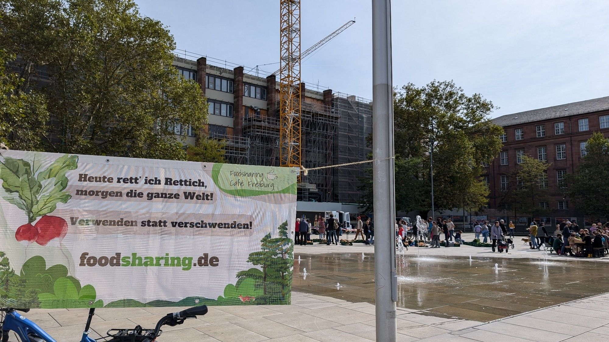 Foodsharing Markt in Freiburg. Im Vordergrund entsprechender Hinweisbanner von foodsharing.de