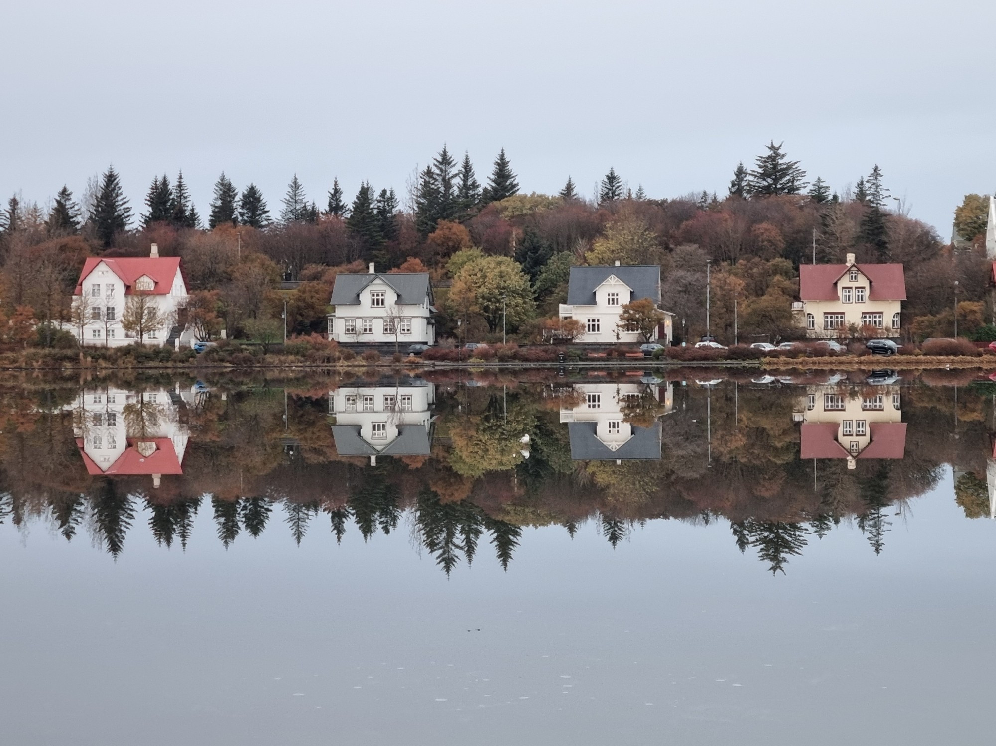 4 houses reflected in a mirrorlike pond